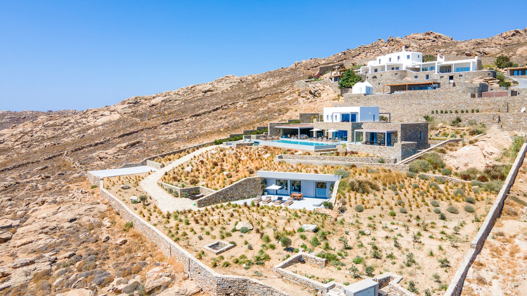 Modern architectural house on a hillside with a clear blue sky