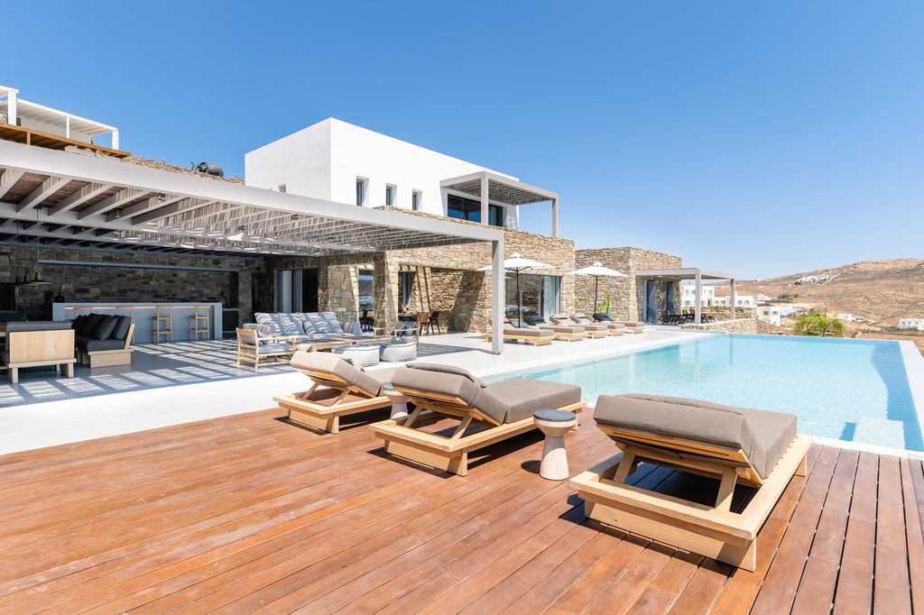 Outdoor deck with lounge chairs and a pool in a luxurious setting