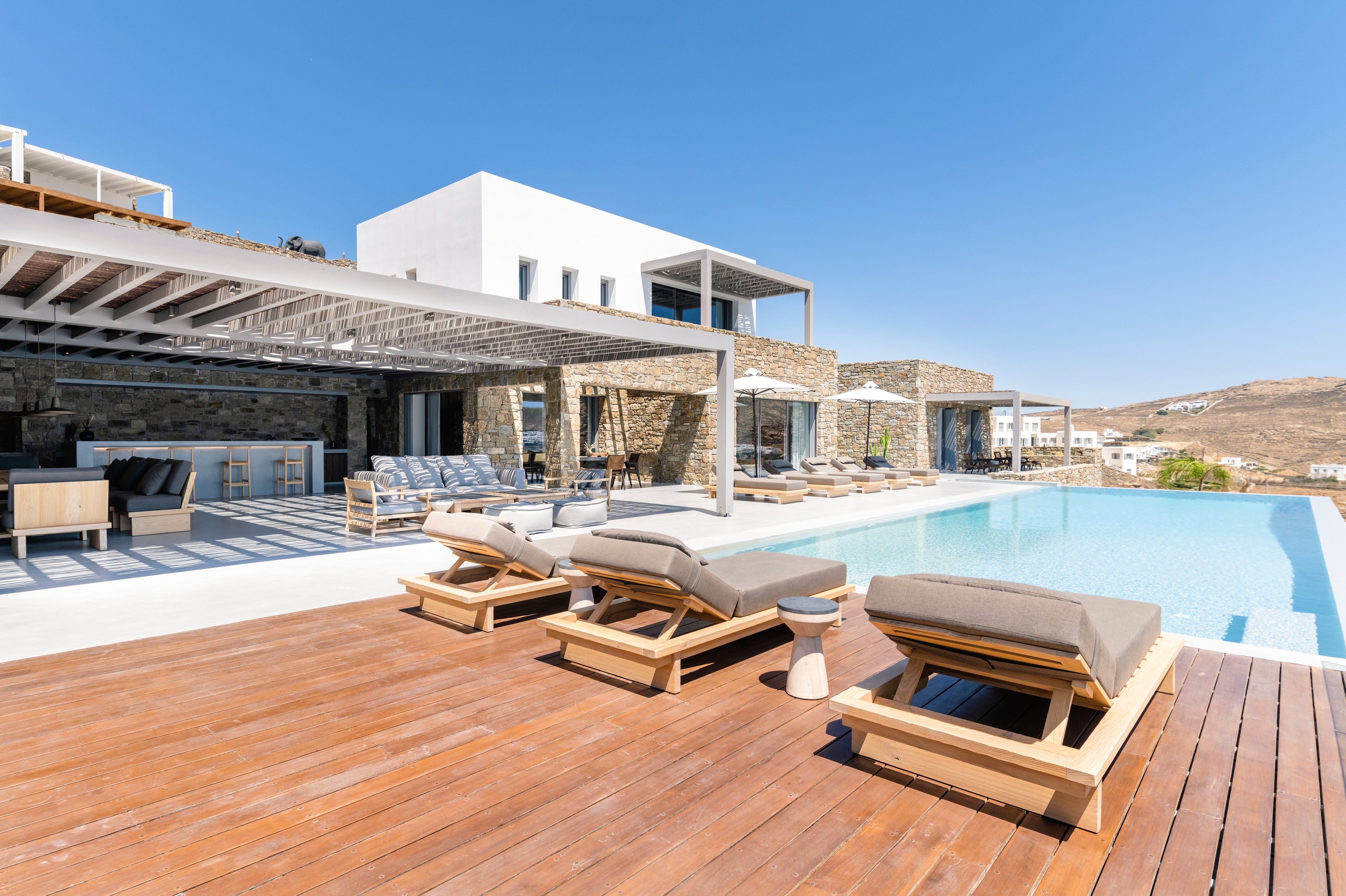 Outdoor deck with lounge chairs and a pool in a luxurious setting