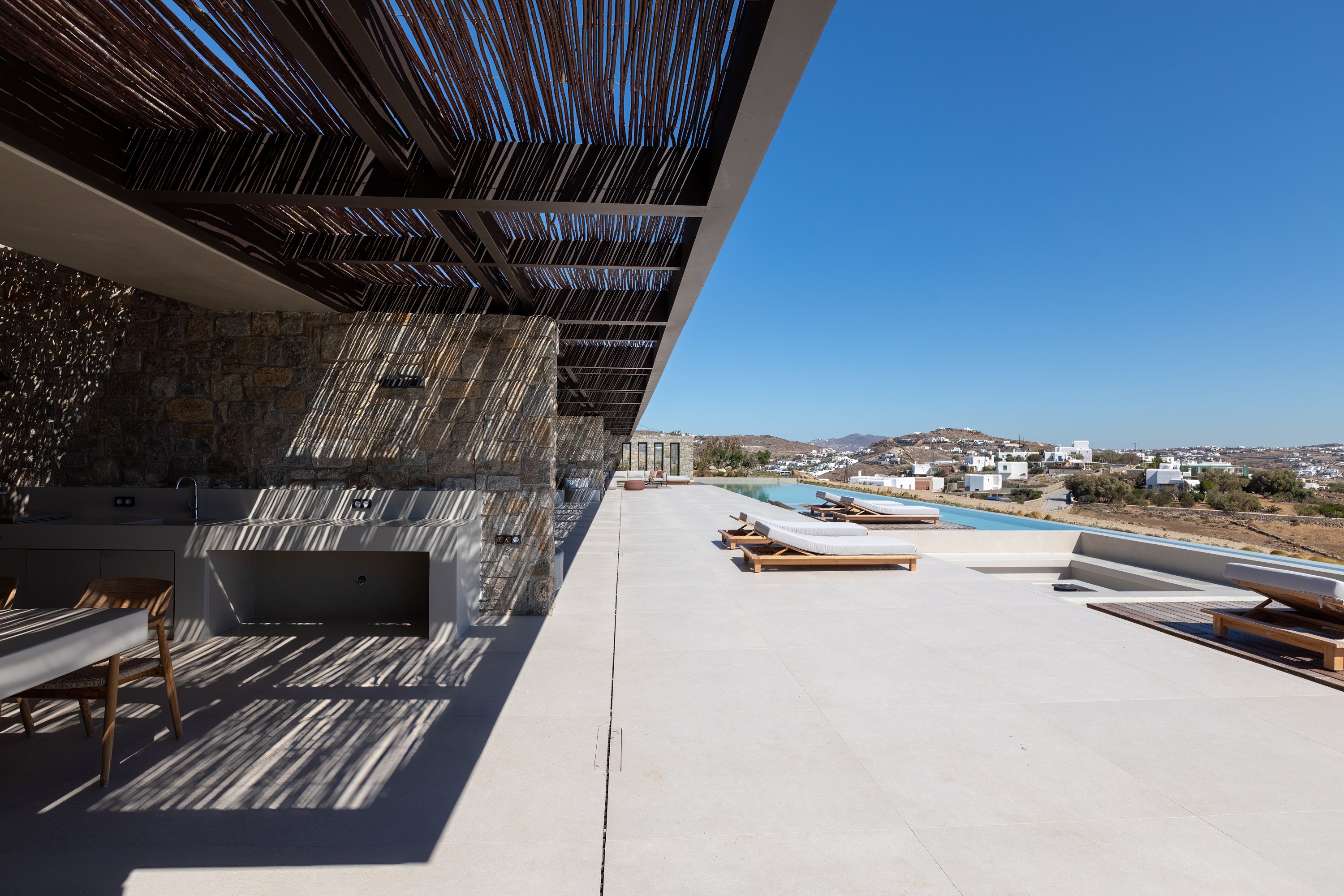 Modern outdoor patio with pool and clear blue sky