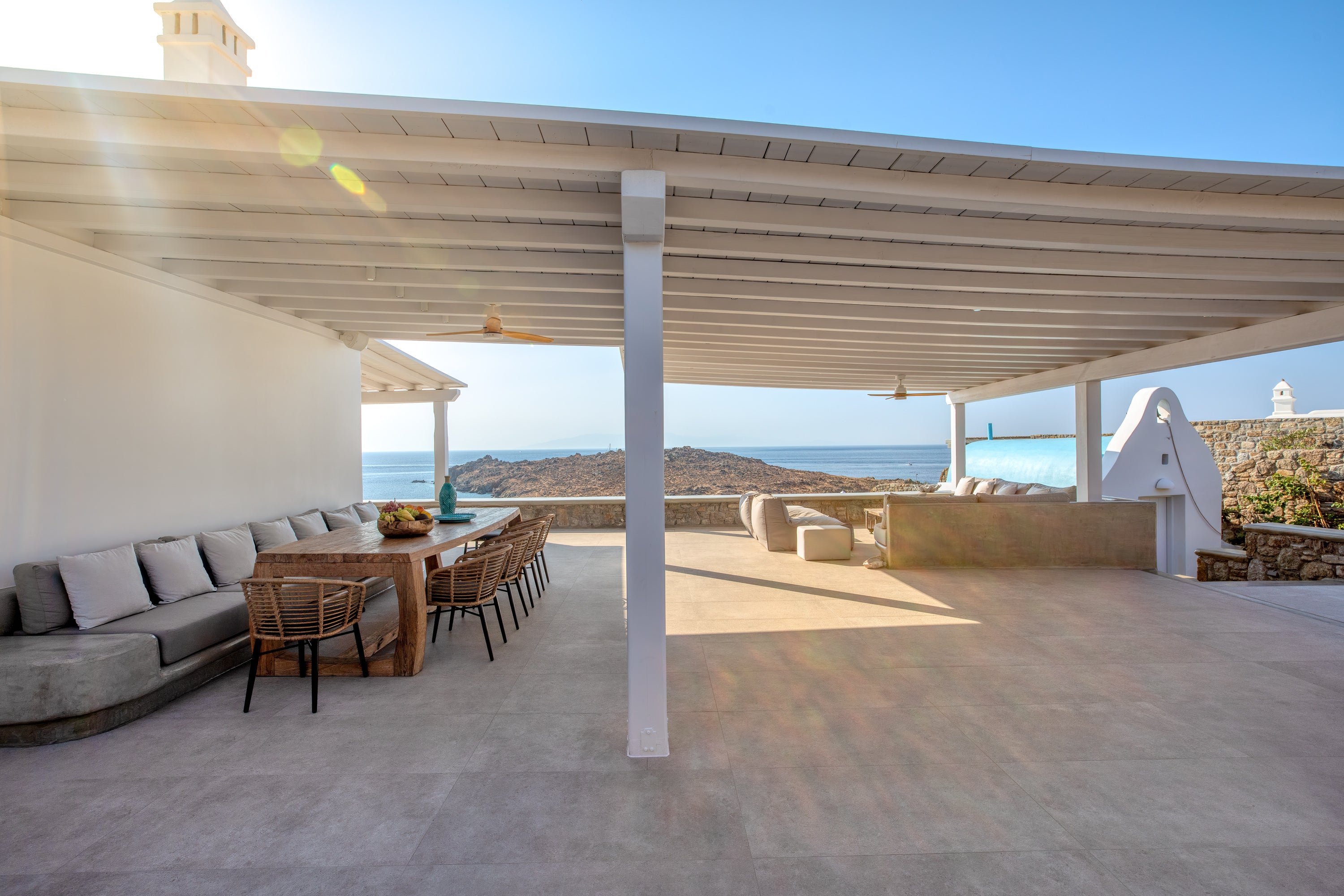 Outdoor patio area with seating and a view of the ocean.