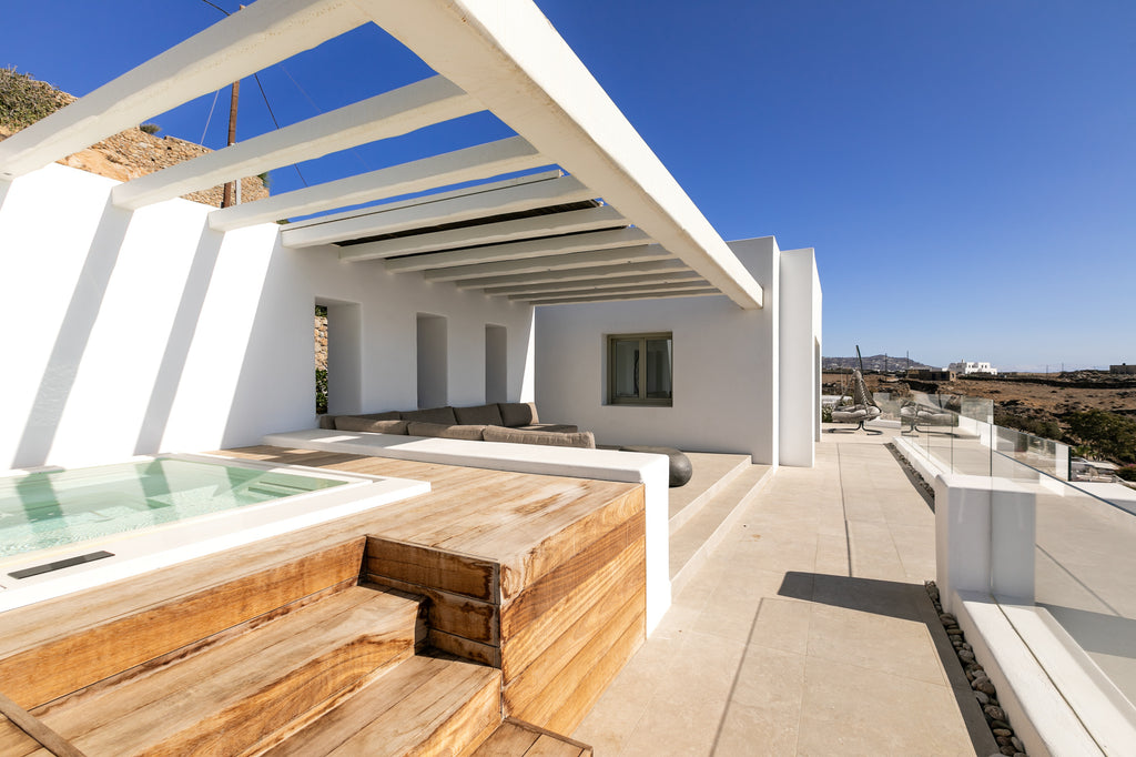 Modern white house with a pool and wooden steps on a clear day