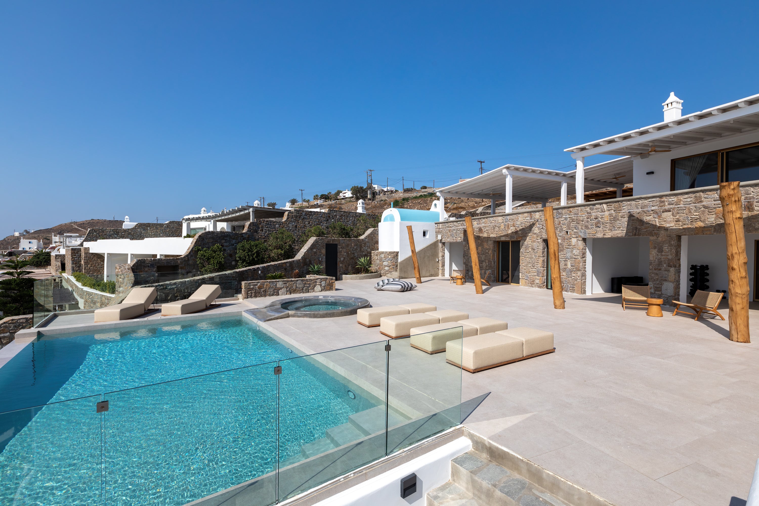 Outdoor pool area with lounge chairs and a clear blue sky