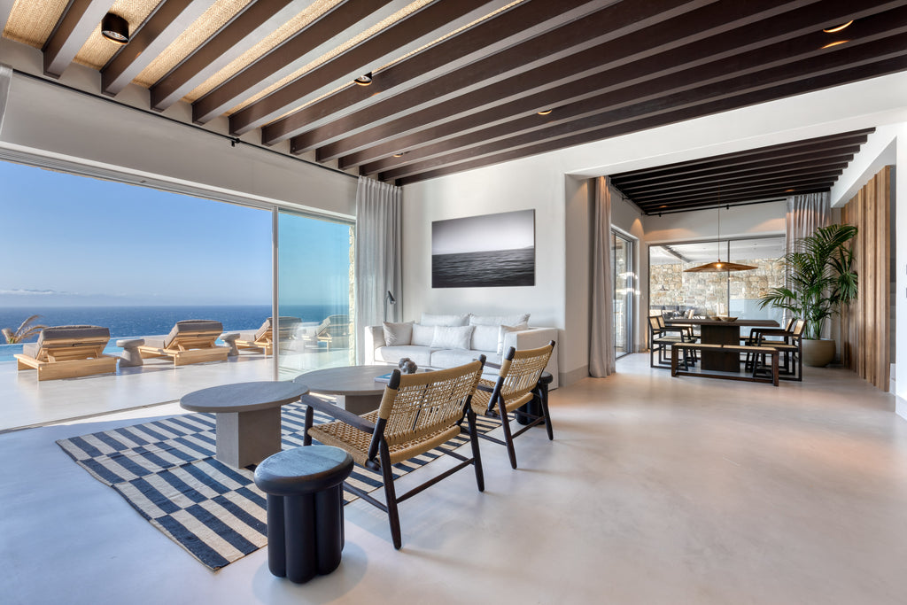 Modern living room with ocean view, wooden beams, and stylish decor.
