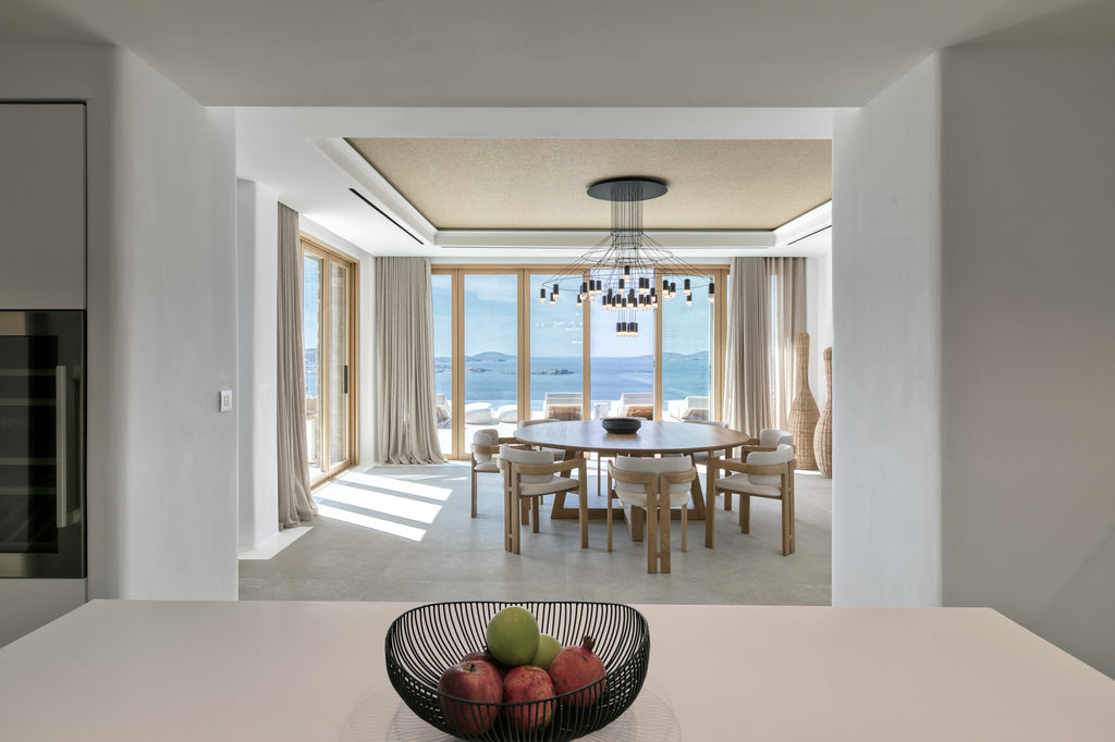 Modern kitchen with a view of a dining area and large windows.