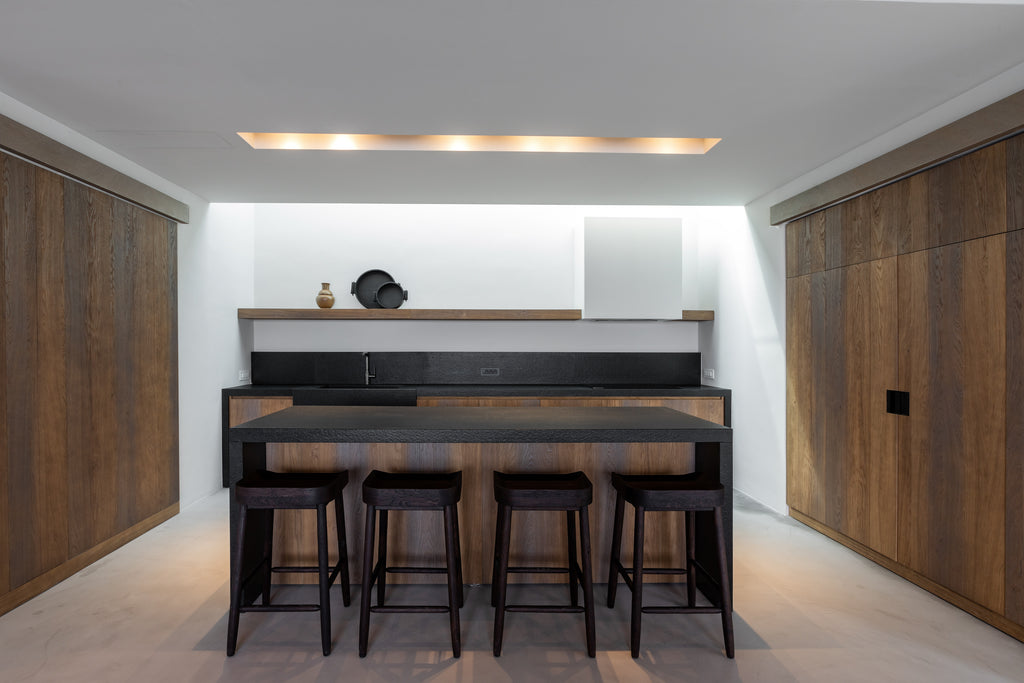 Modern kitchen with wooden cabinets, a bar counter, and stools.