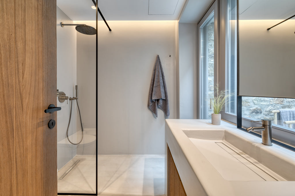 Modern bathroom with shower, sink, and large window