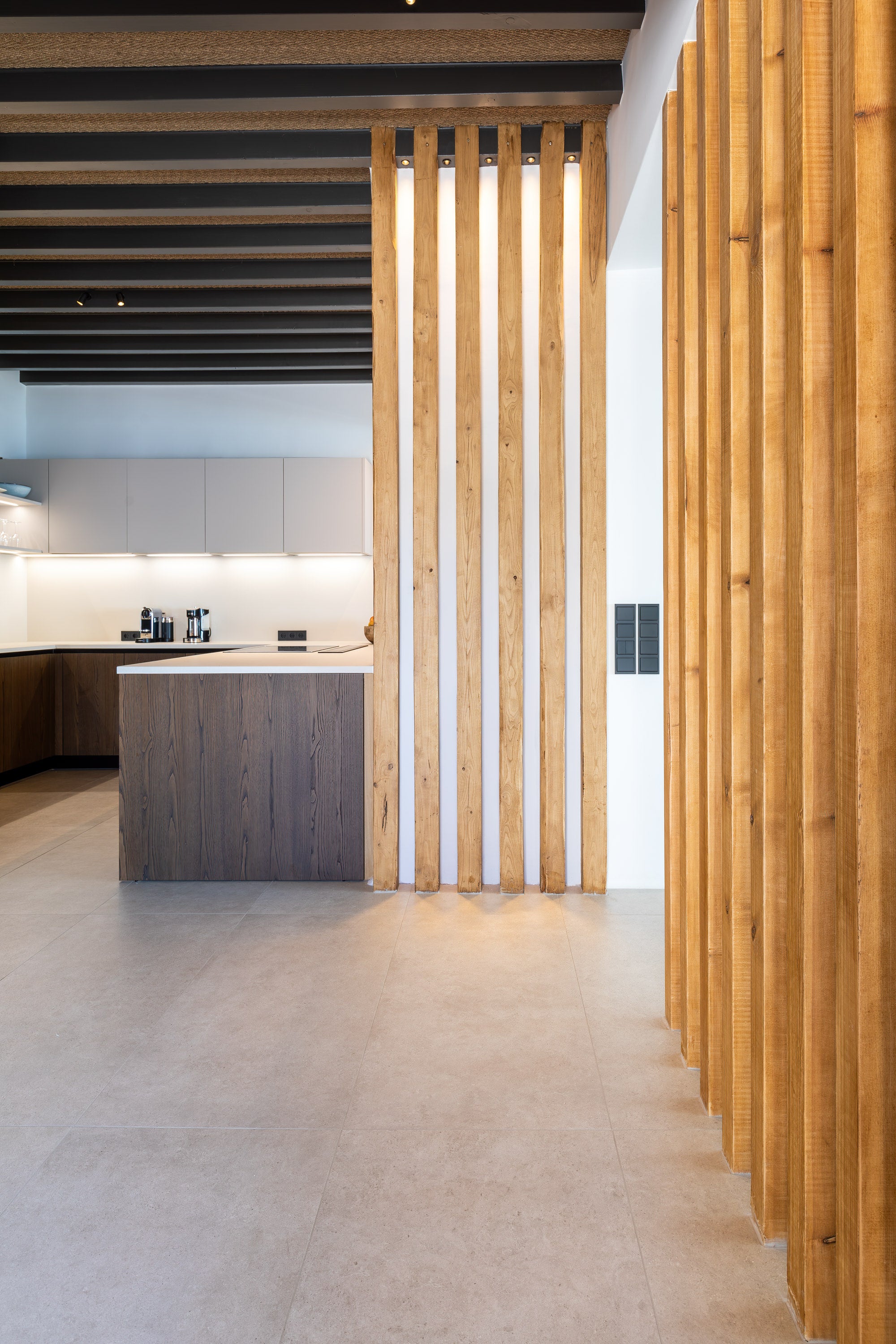 Modern kitchen with wooden slat wall and white cabinets