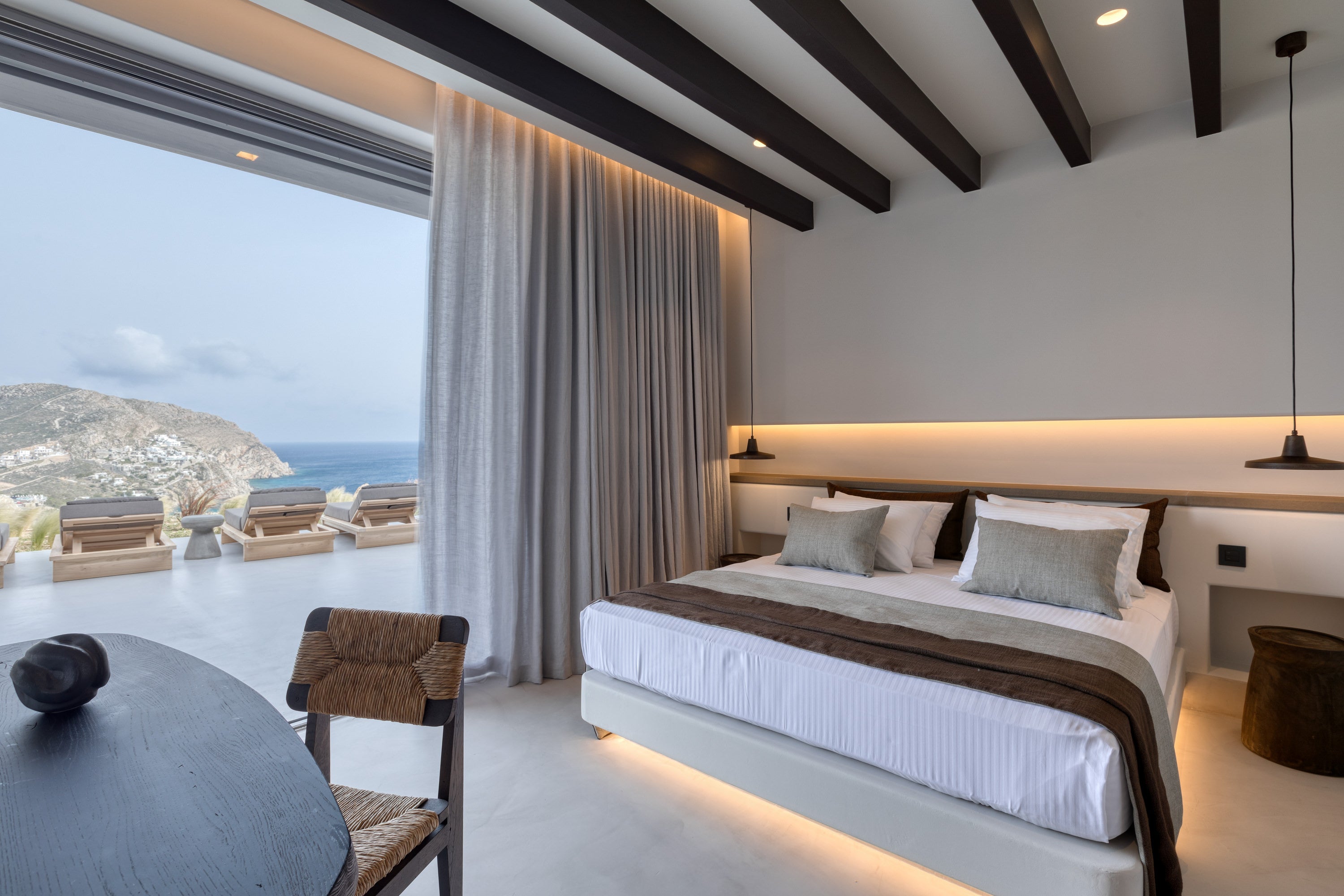 Modern bedroom with a view of a coastal landscape
