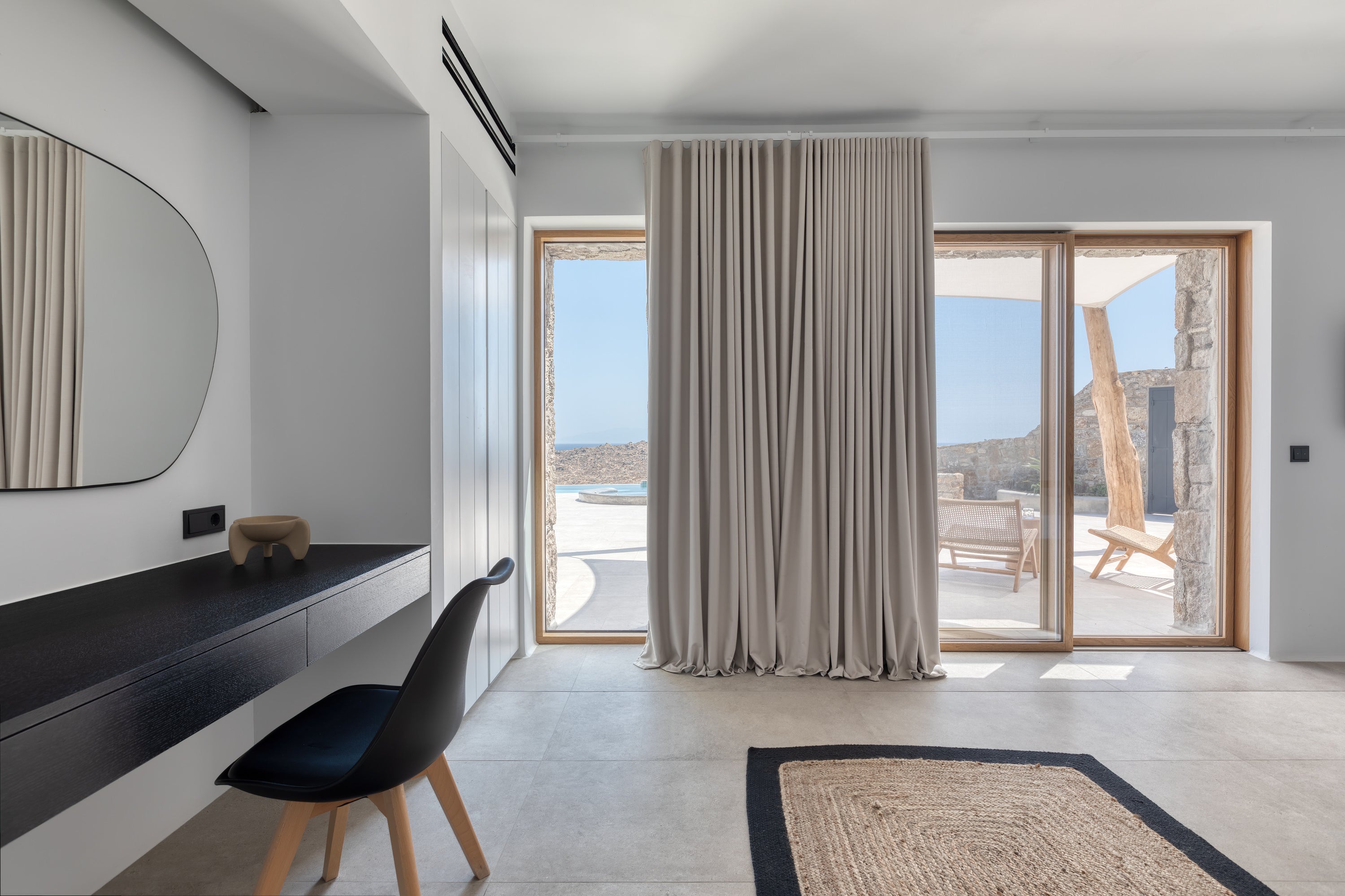 Modern interior with a desk, chair, and large windows overlooking a scenic view.