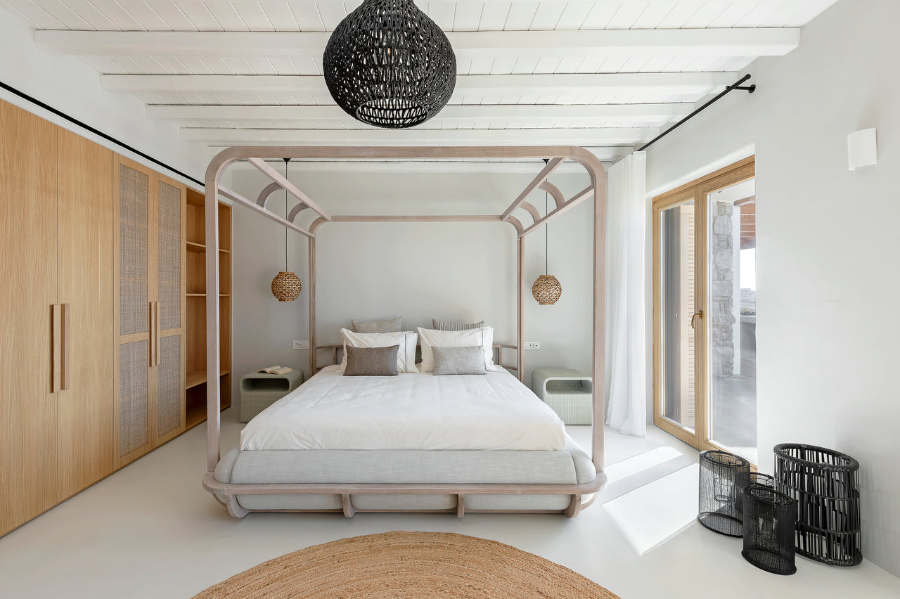 Modern bedroom with a canopy bed, wooden wardrobe, and large window.