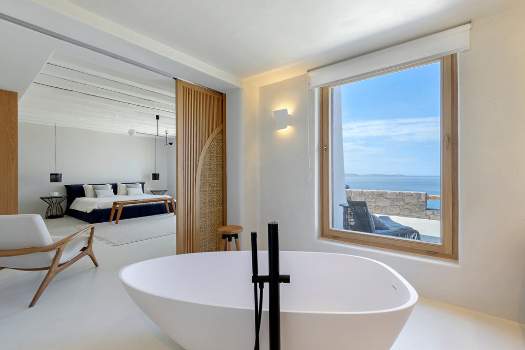 Modern bathroom with a large window overlooking the ocean.