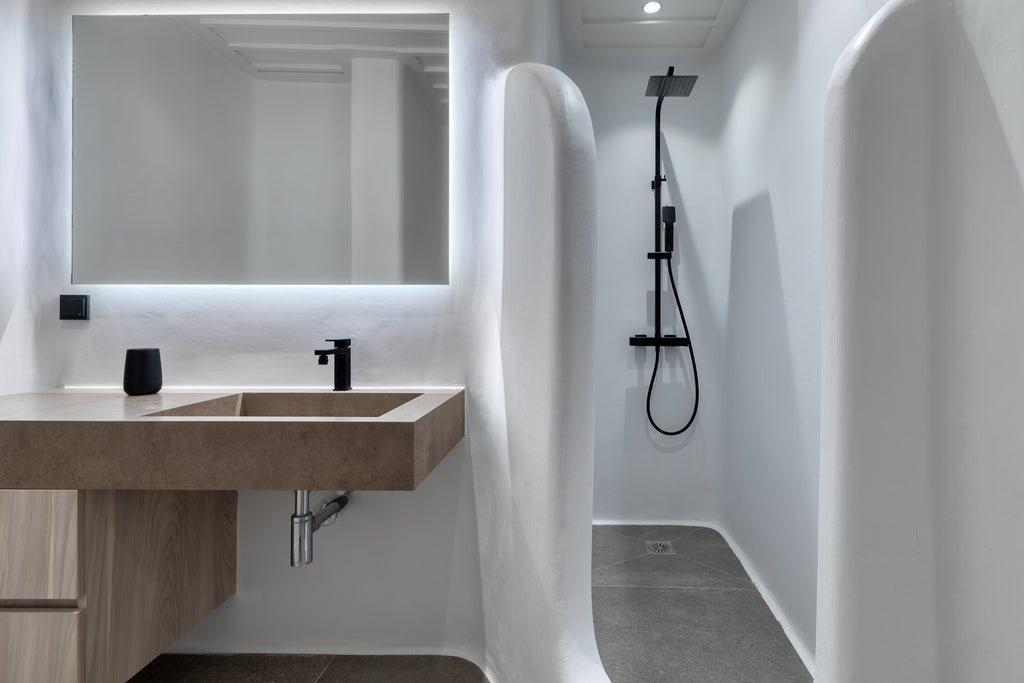 Modern bathroom with a sink, mirror, and shower setup.