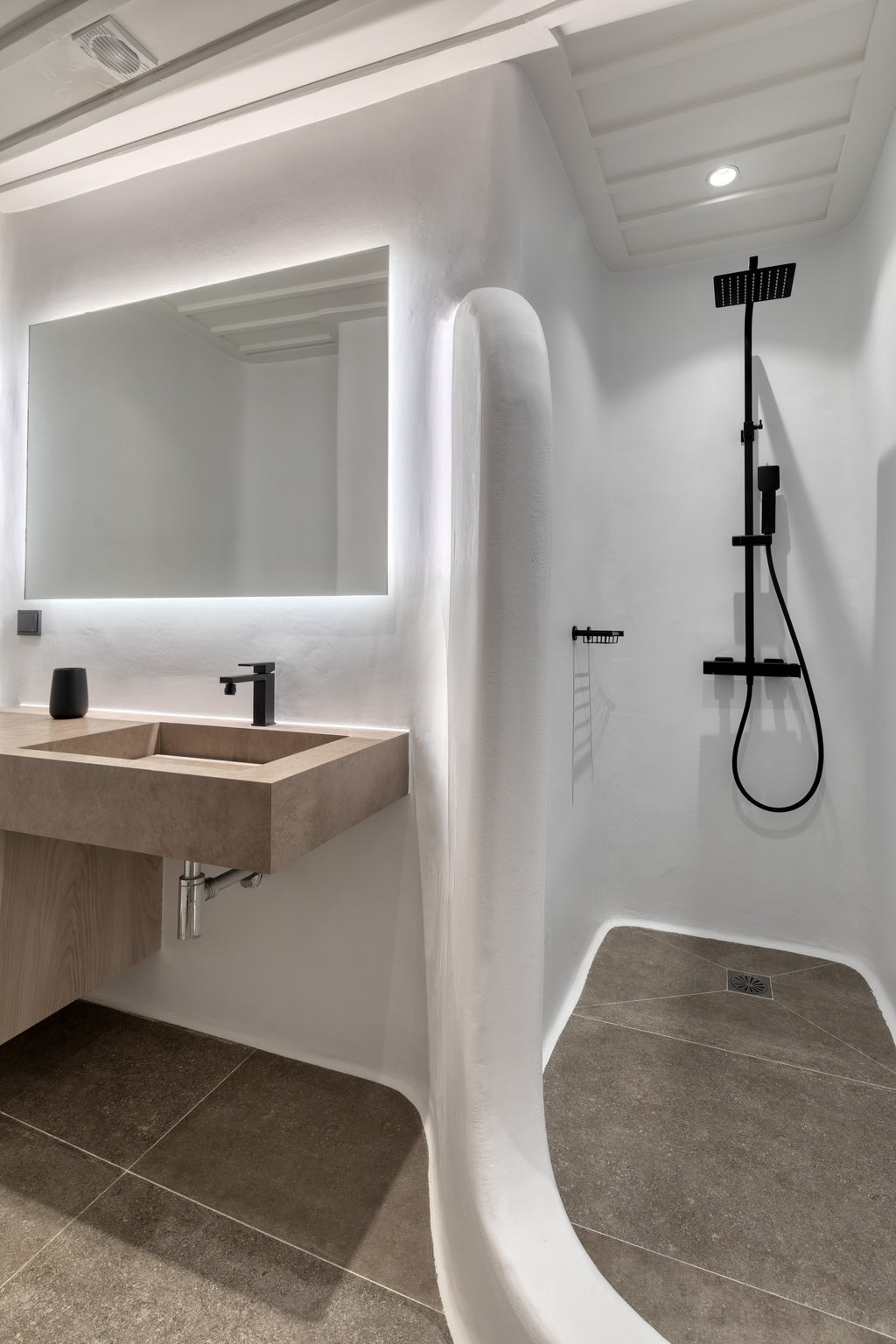 Modern bathroom with shower area, sink, and mirror.