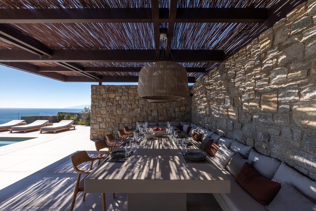 Outdoor dining area with stone wall and ocean view