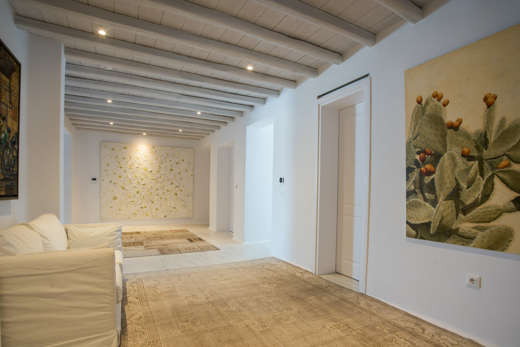 Modern interior with white walls, wooden floor, and decorative art pieces.