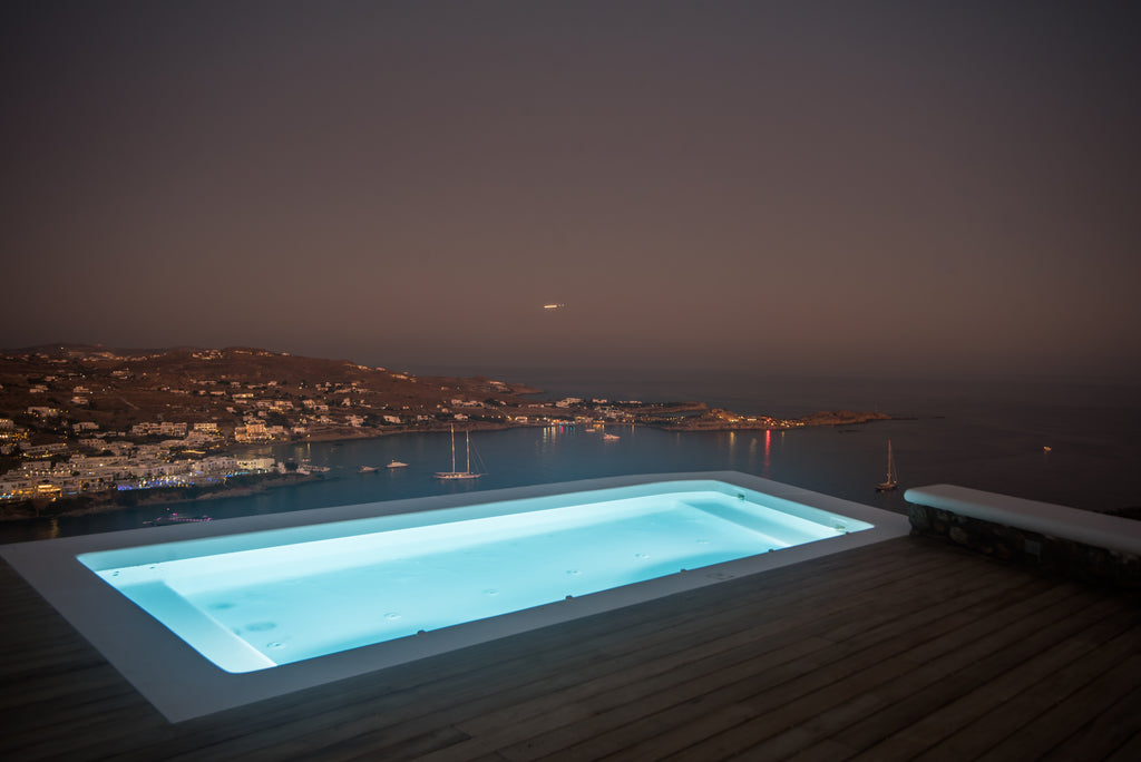 Pool with a view of a coastal town at night