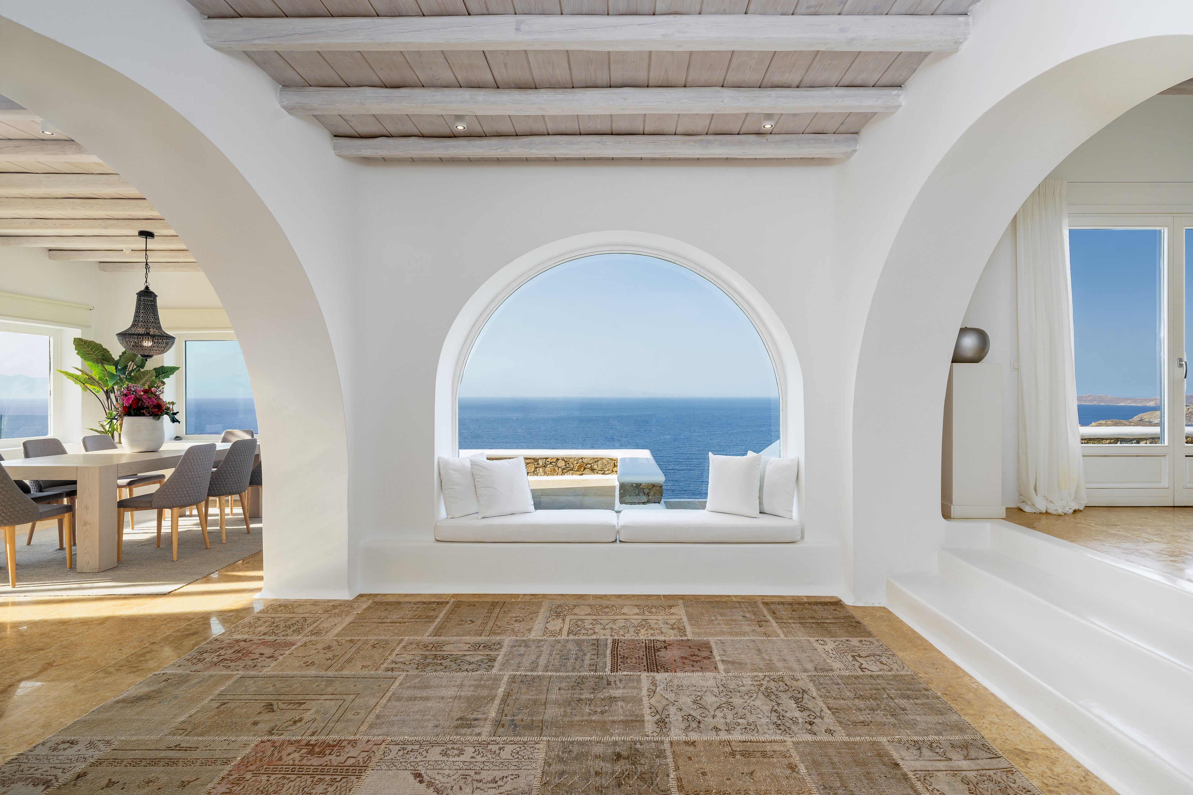 Modern interior with white walls, wooden floor, and ocean view