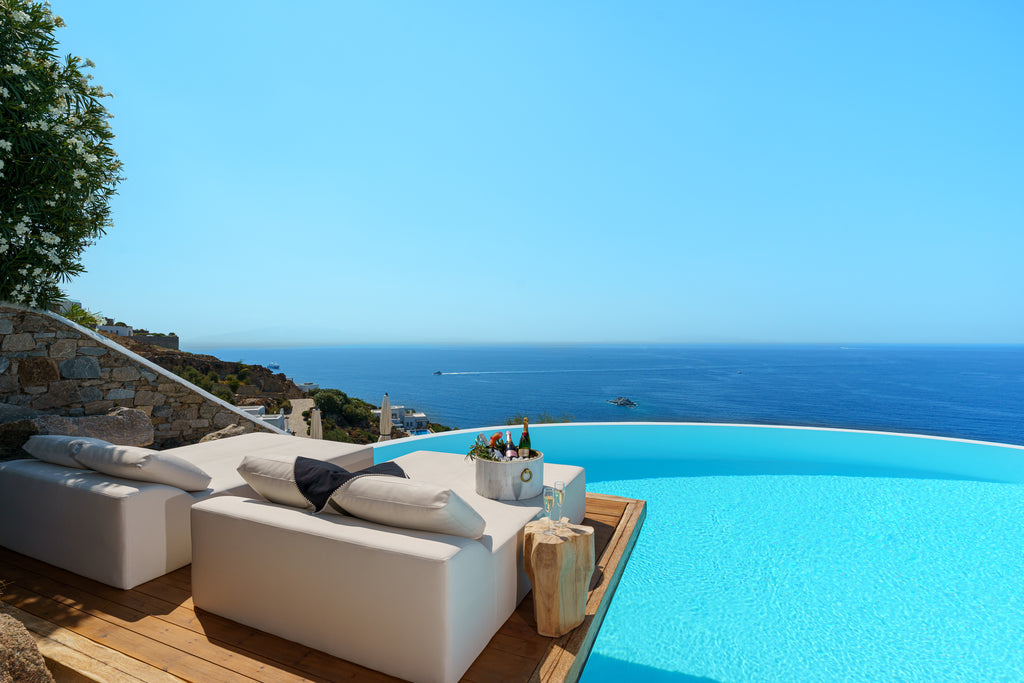 Outdoor seating area with a view of the ocean and infinity pool.
