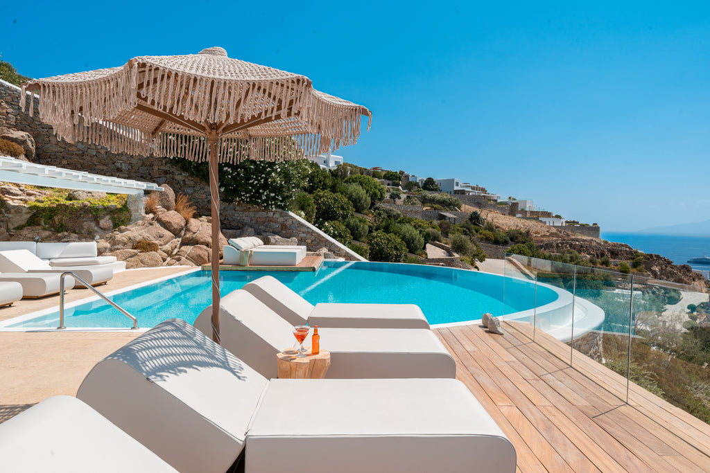 Outdoor pool area with lounge chairs and a view of the ocean.