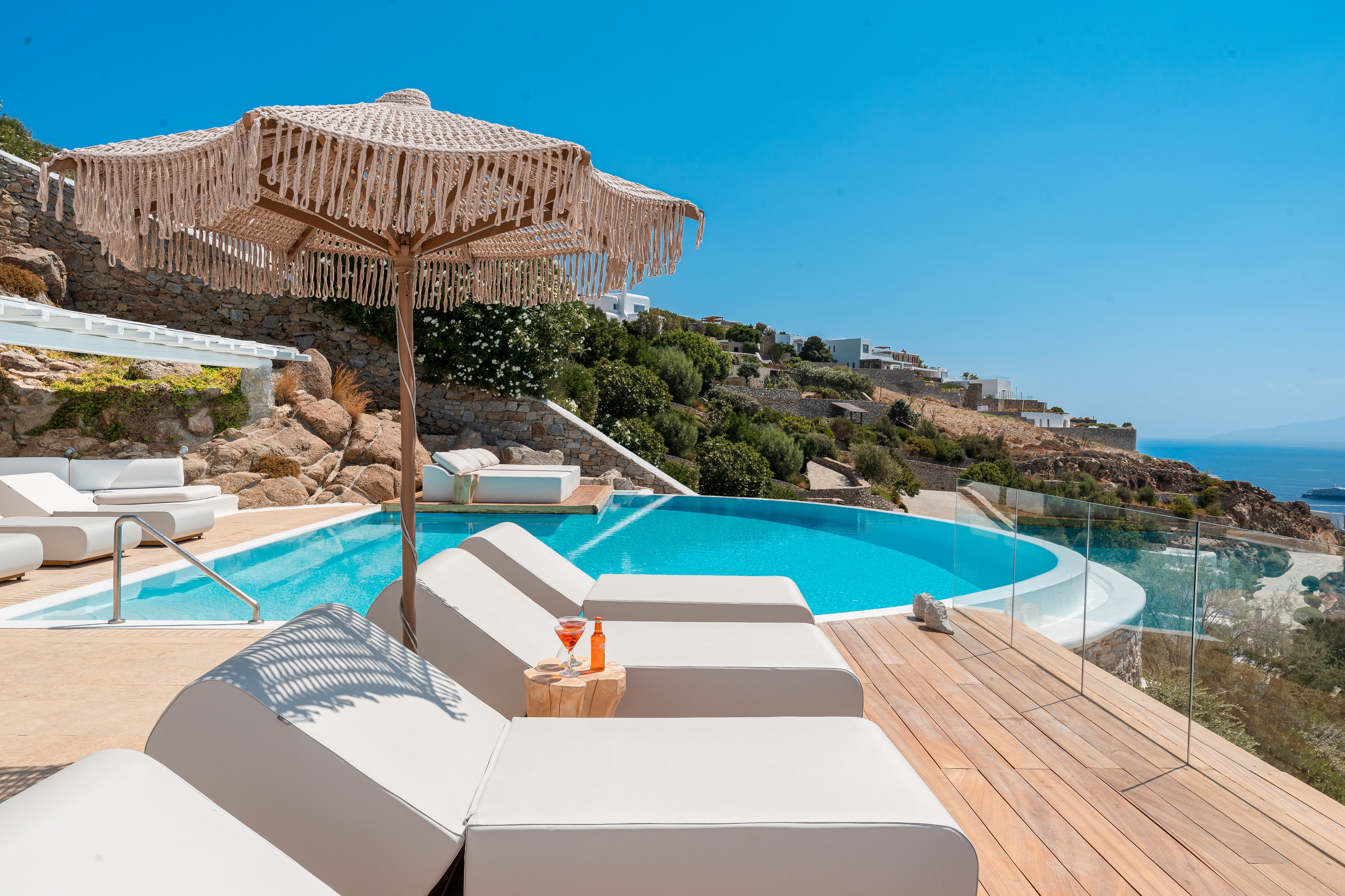 Outdoor pool area with lounge chairs and a view of the ocean.