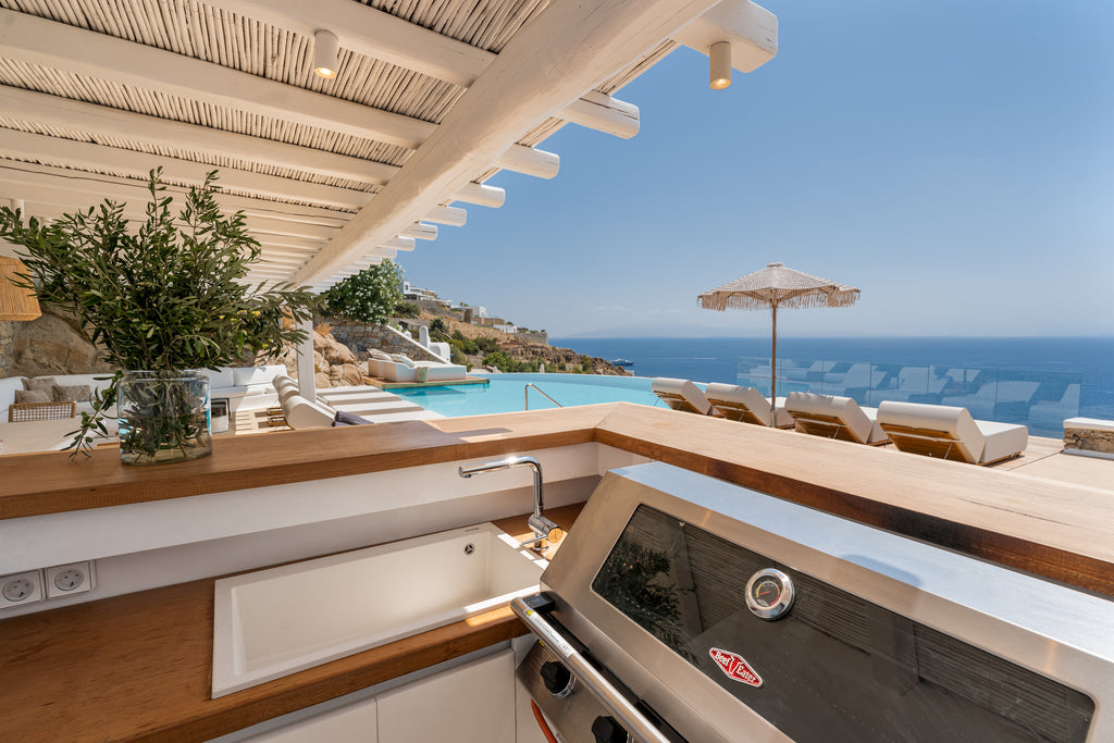 Outdoor kitchen with ocean view and pool in the background