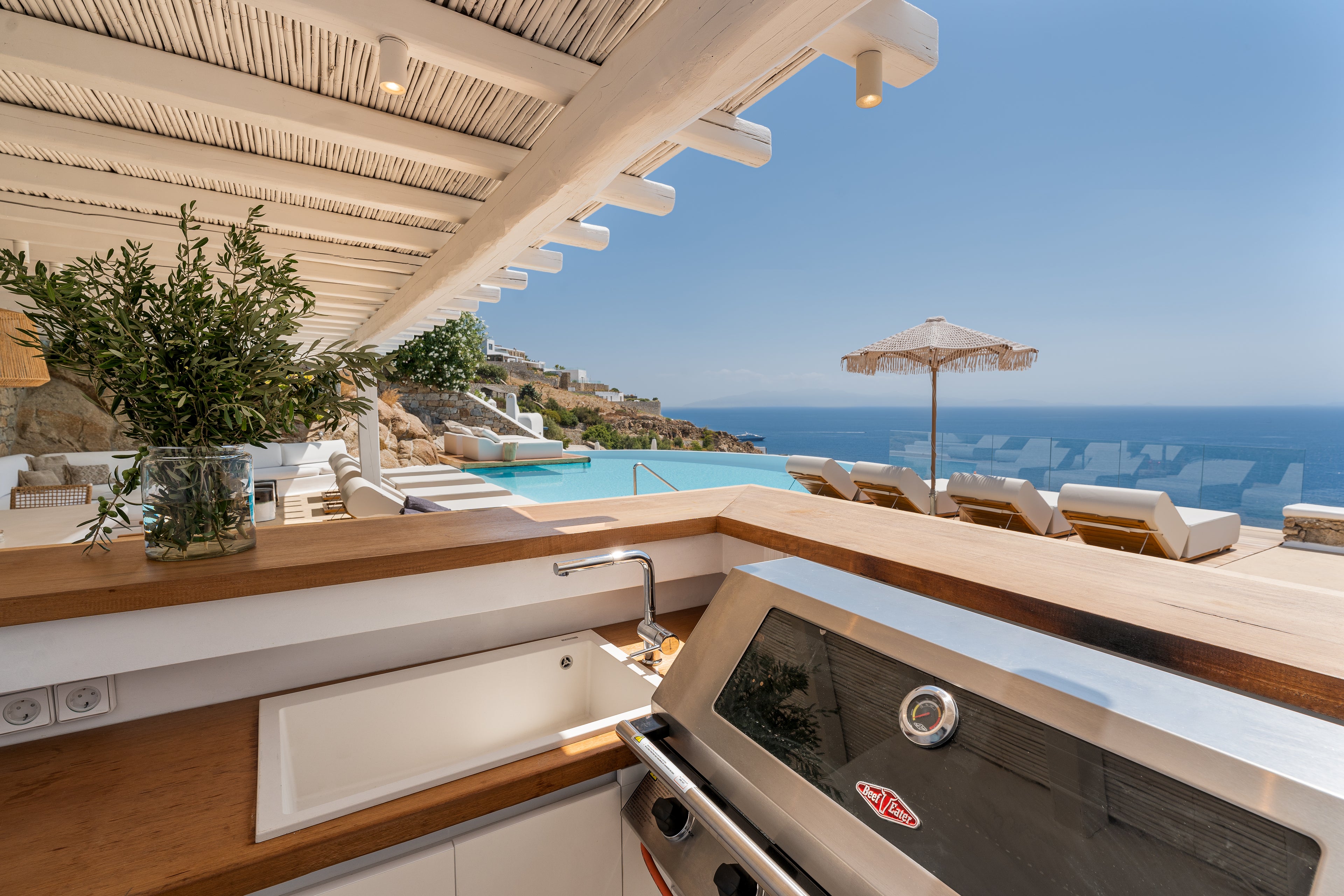 Outdoor kitchen with ocean view and pool in the background