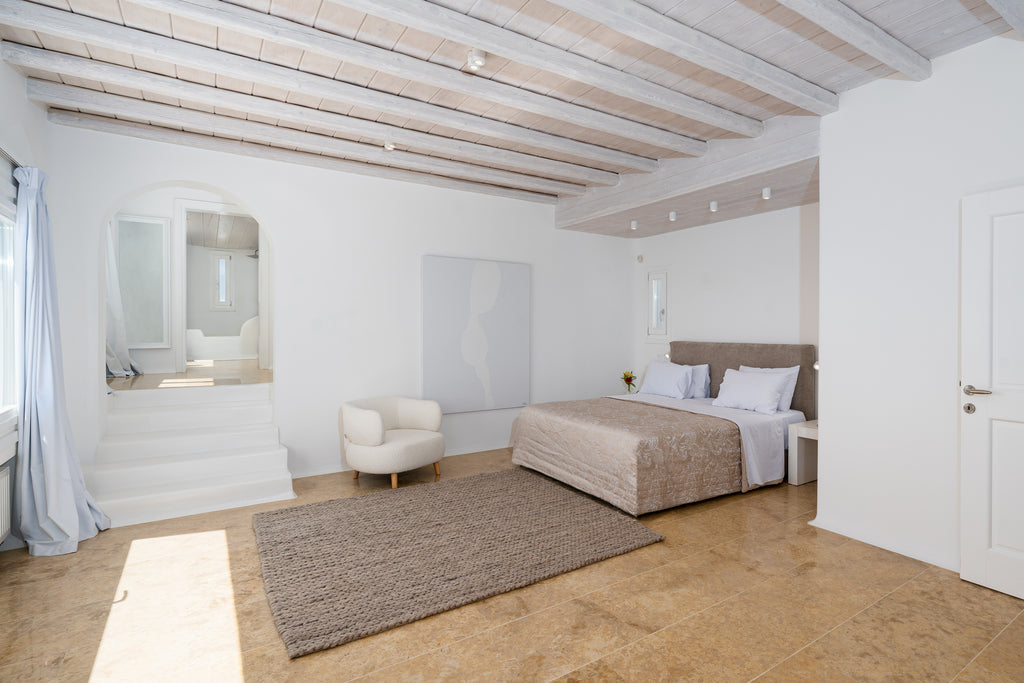 Modern bedroom with wooden floor, bed, and mirrors on the wall.