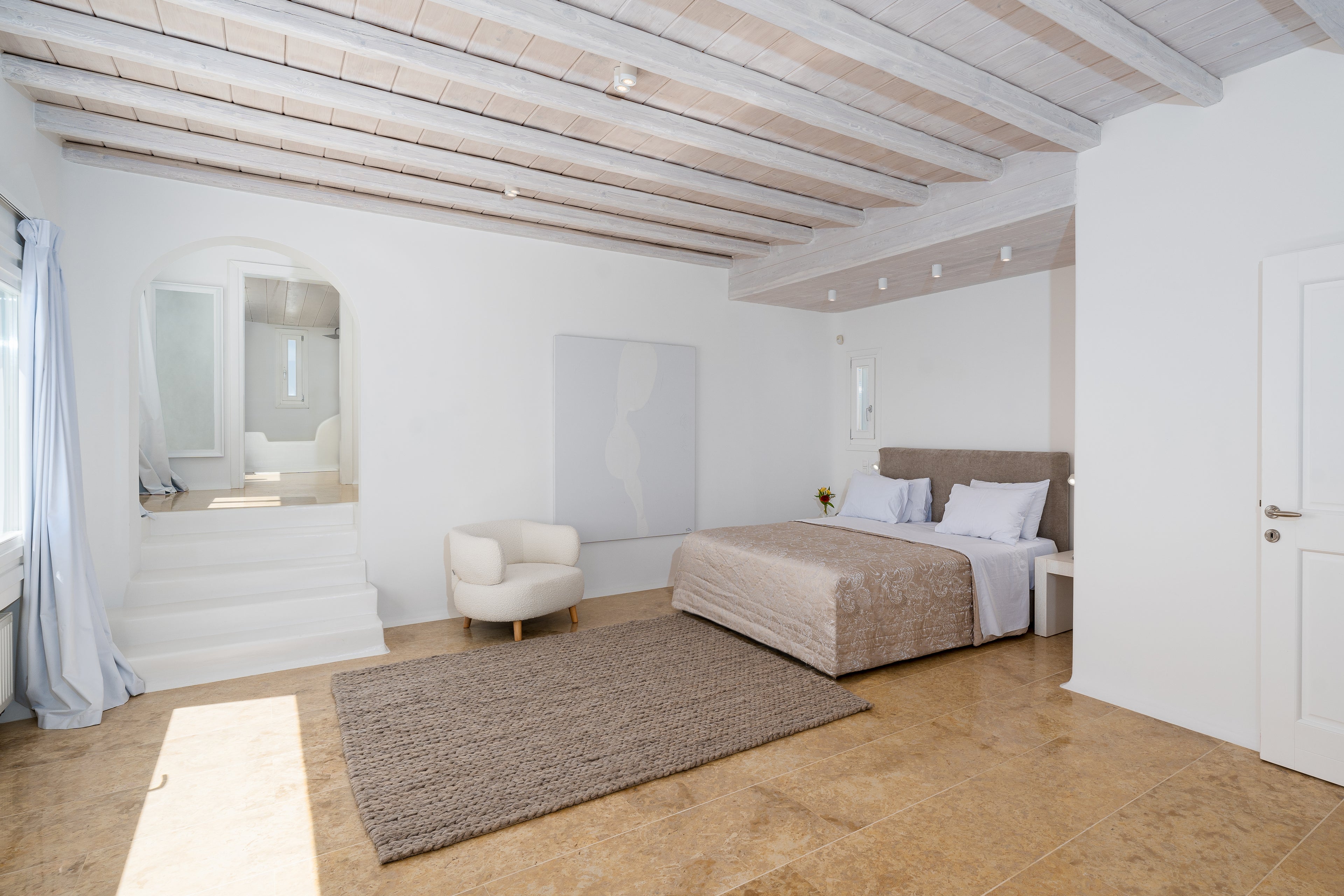 Modern bedroom with wooden floor, bed, and mirrors on the wall.