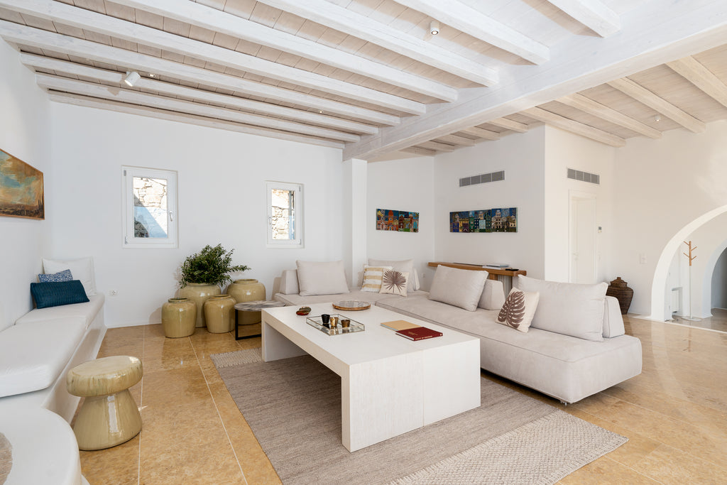 Modern living room with white furniture and wooden beams
