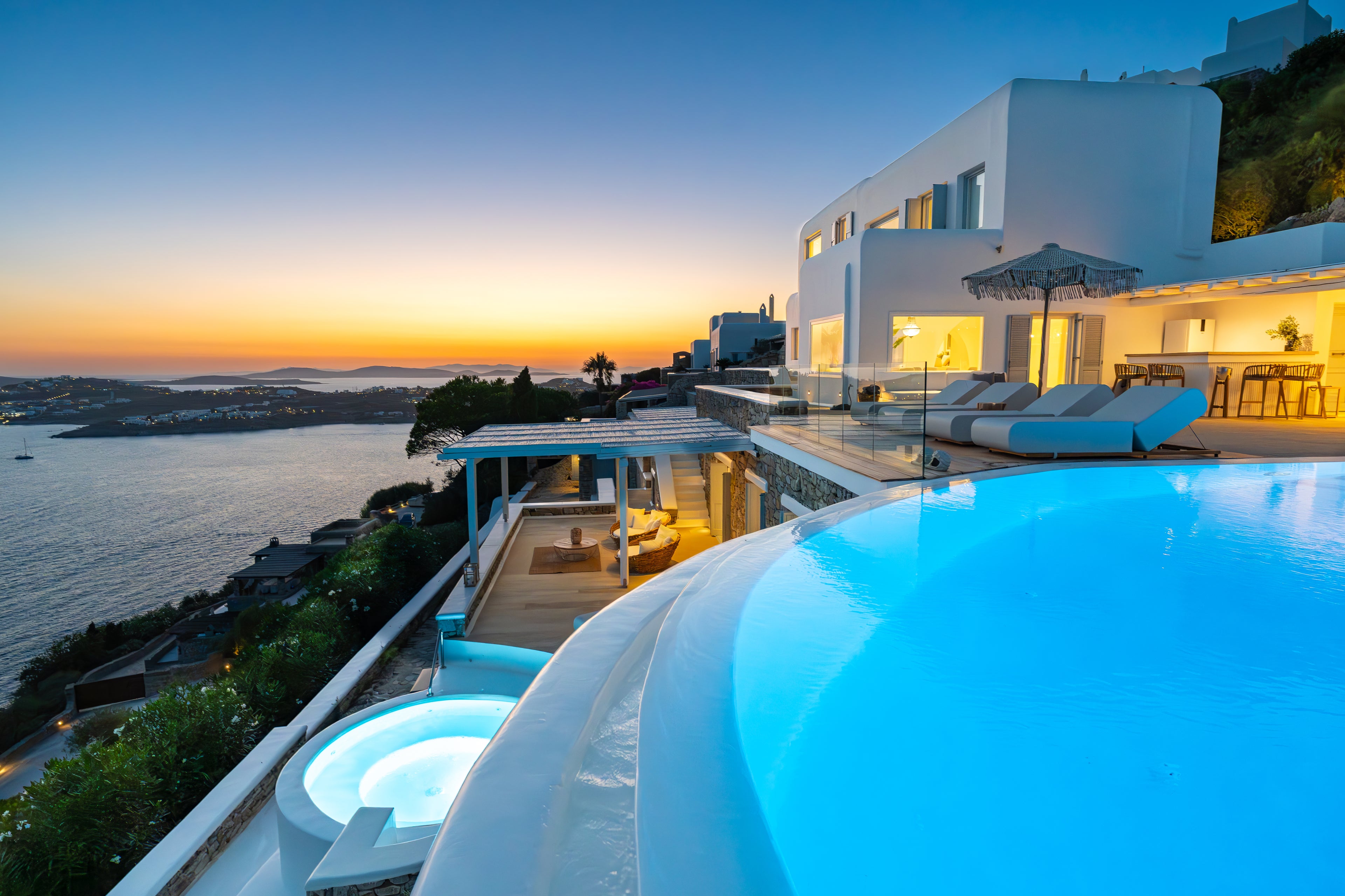 Luxury villa with pool and sunset over water