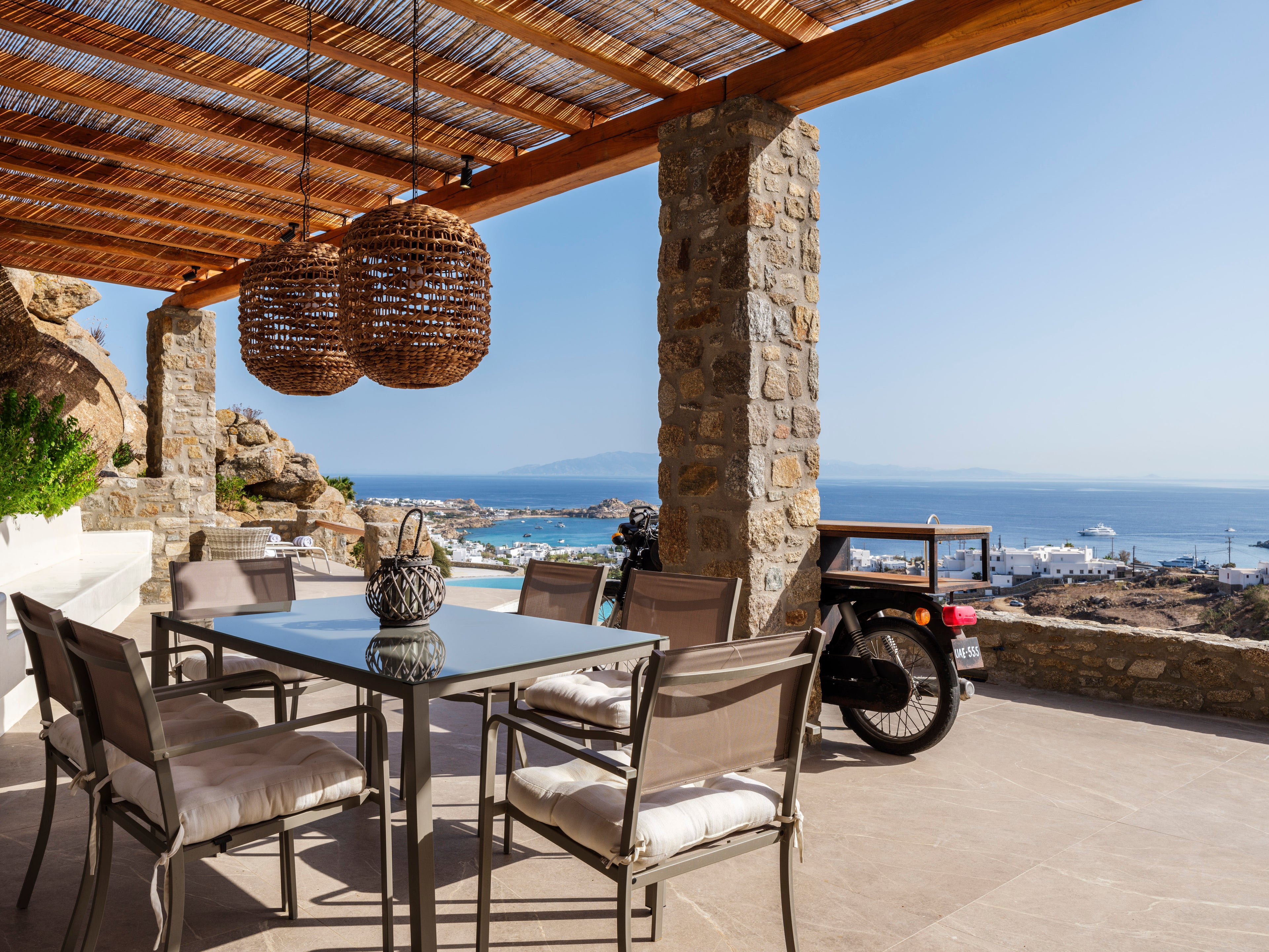 Outdoor patio with table and chairs overlooking a scenic view of the ocean.