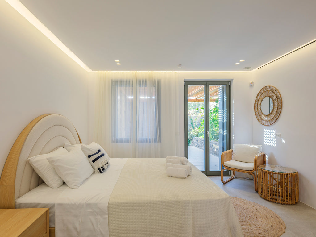 Modern bedroom with a bed, chair, and window view