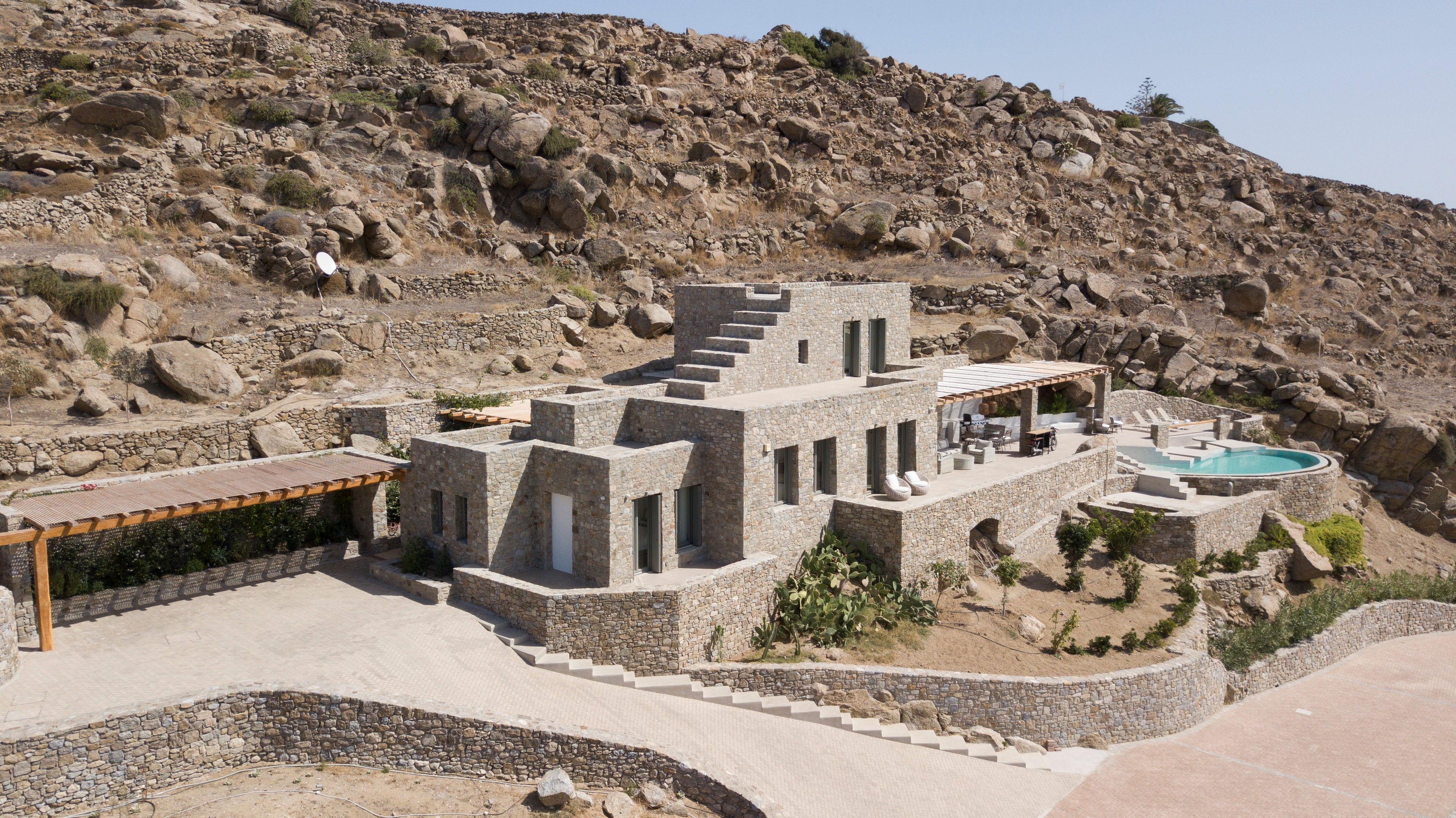Stone building with a pool on a rocky hillside