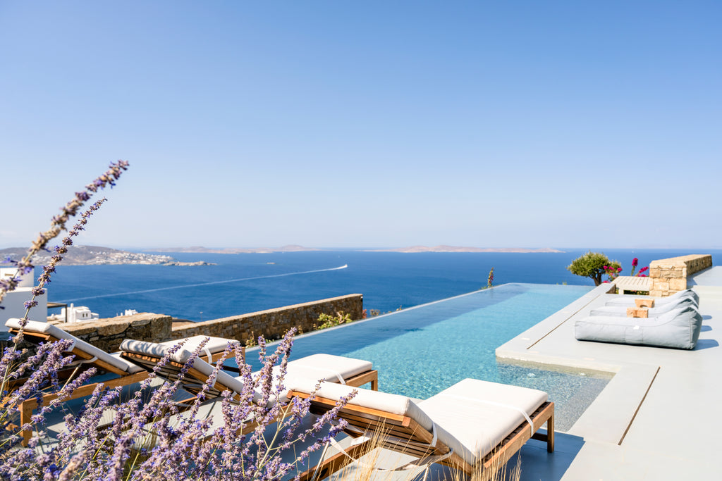 Luxury outdoor pool area with ocean view and sun loungers.
