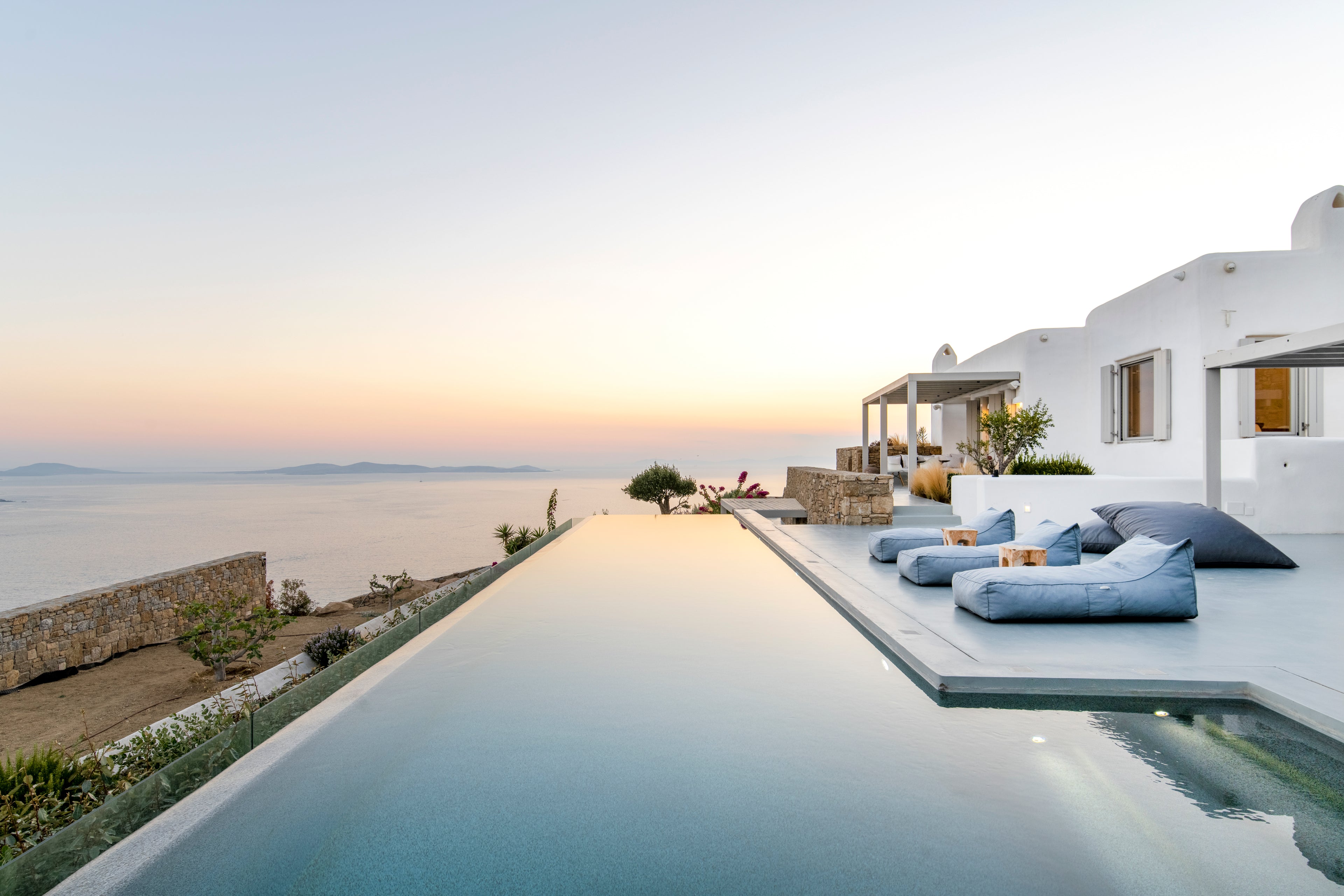 Luxury villa with infinity pool and outdoor seating area overlooking the sea.