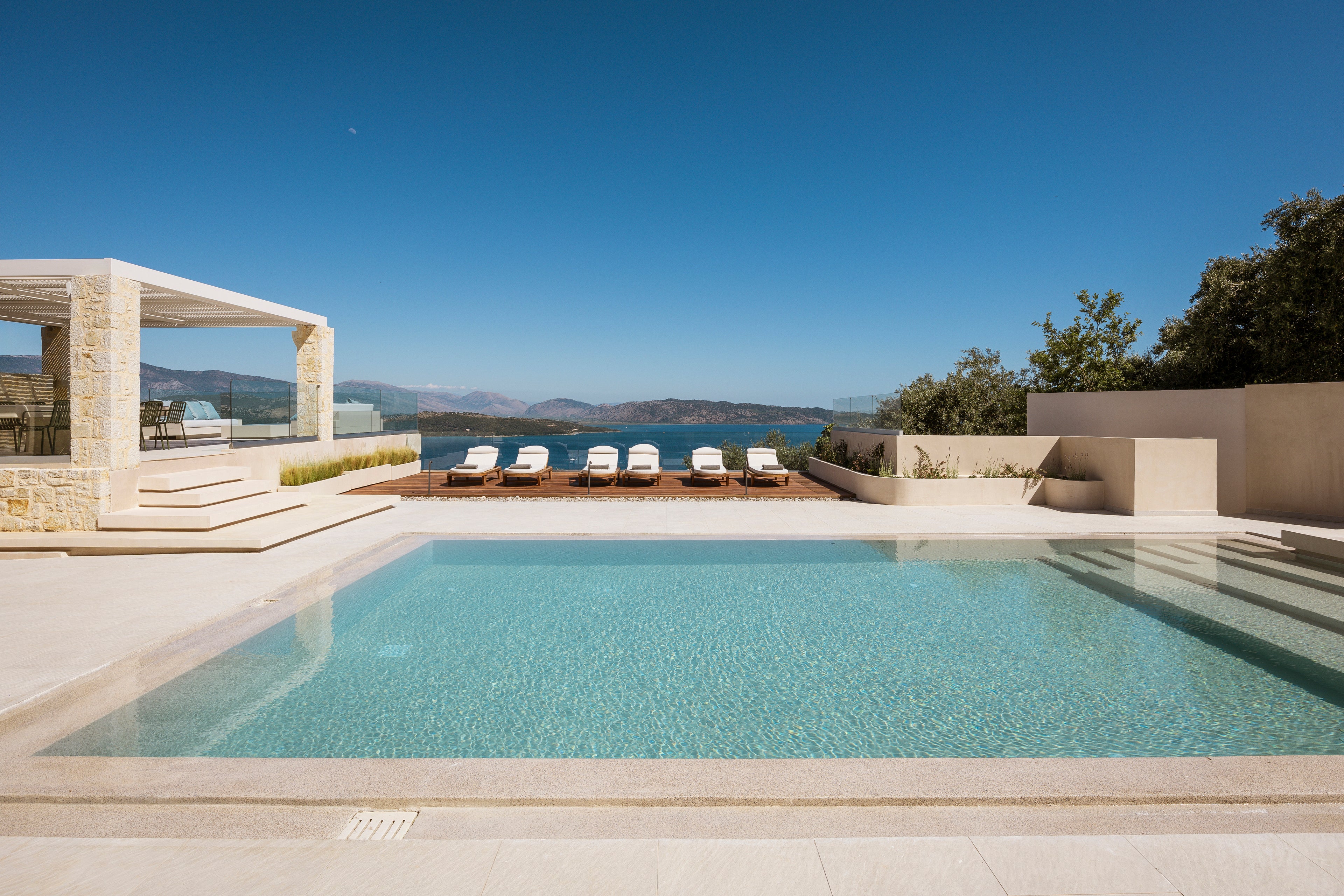 Modern pool area with lounge chairs and scenic view