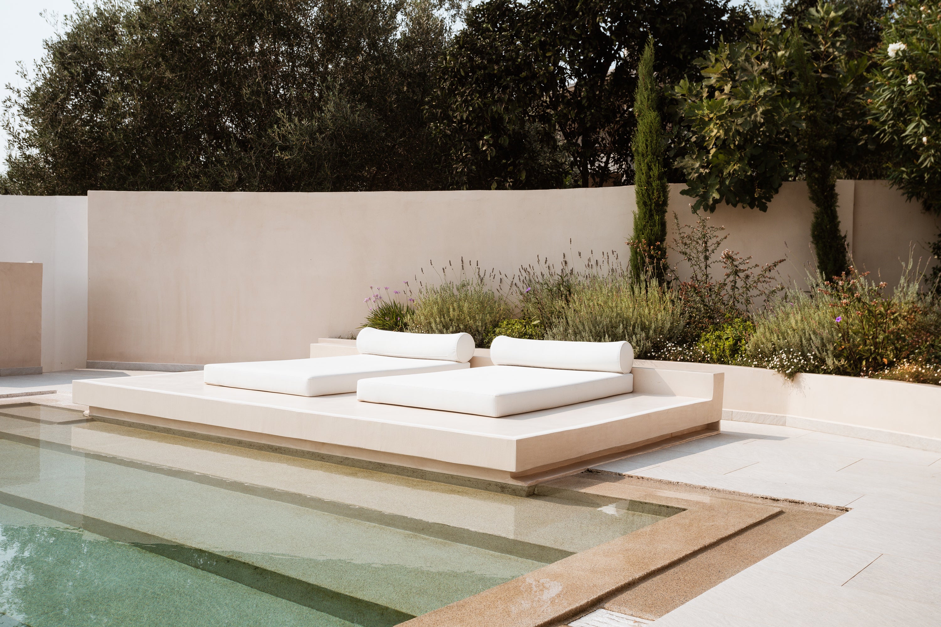 Modern outdoor seating area with cushions by a pool