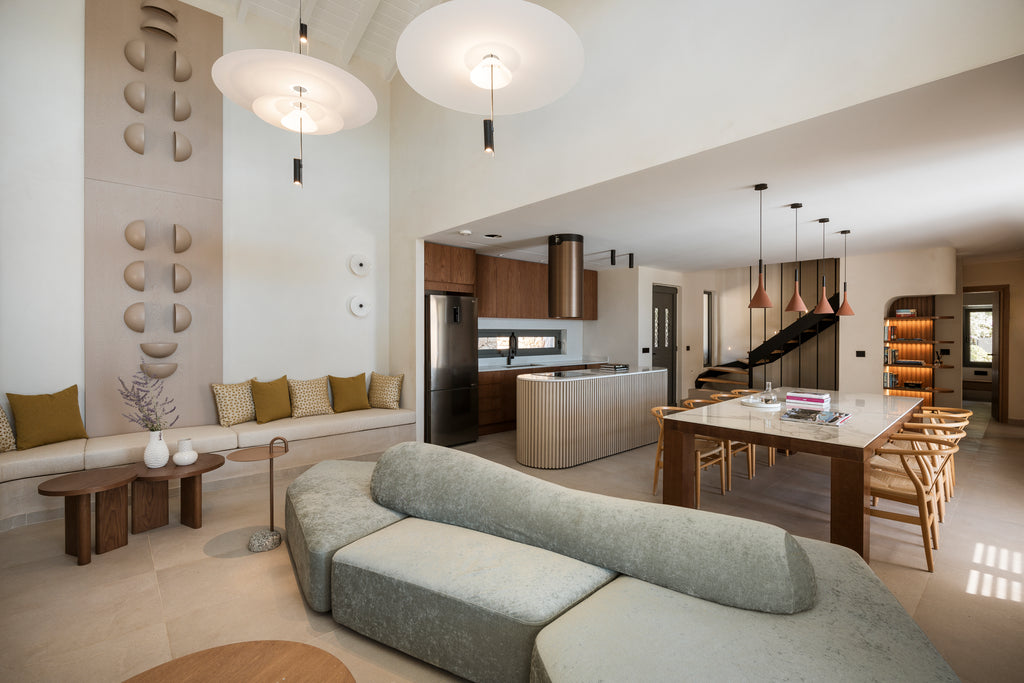 Modern living room with gray sofa, wooden coffee table, and kitchen in the background.