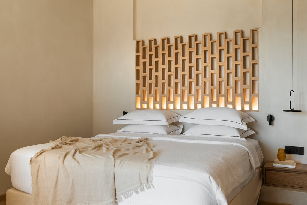Bedroom with a decorative wooden headboard and soft lighting.