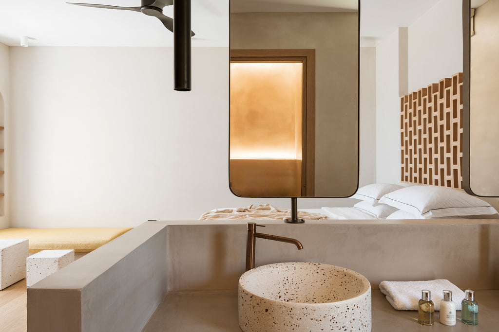 Modern bathroom with a sink, mirror, and decorative elements.