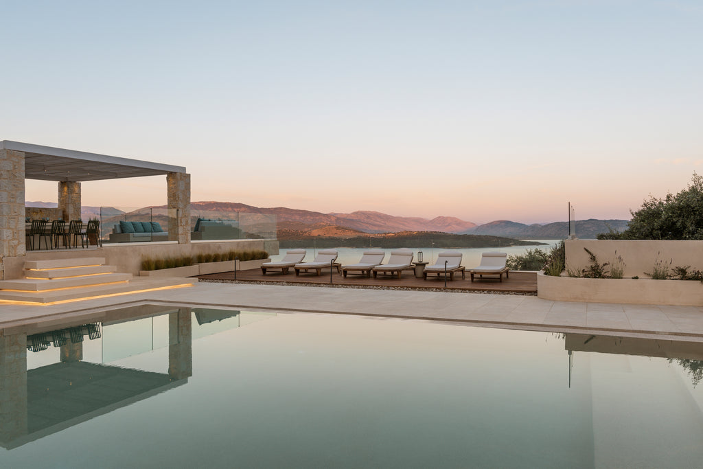 Luxury outdoor pool area with lounge chairs and scenic view