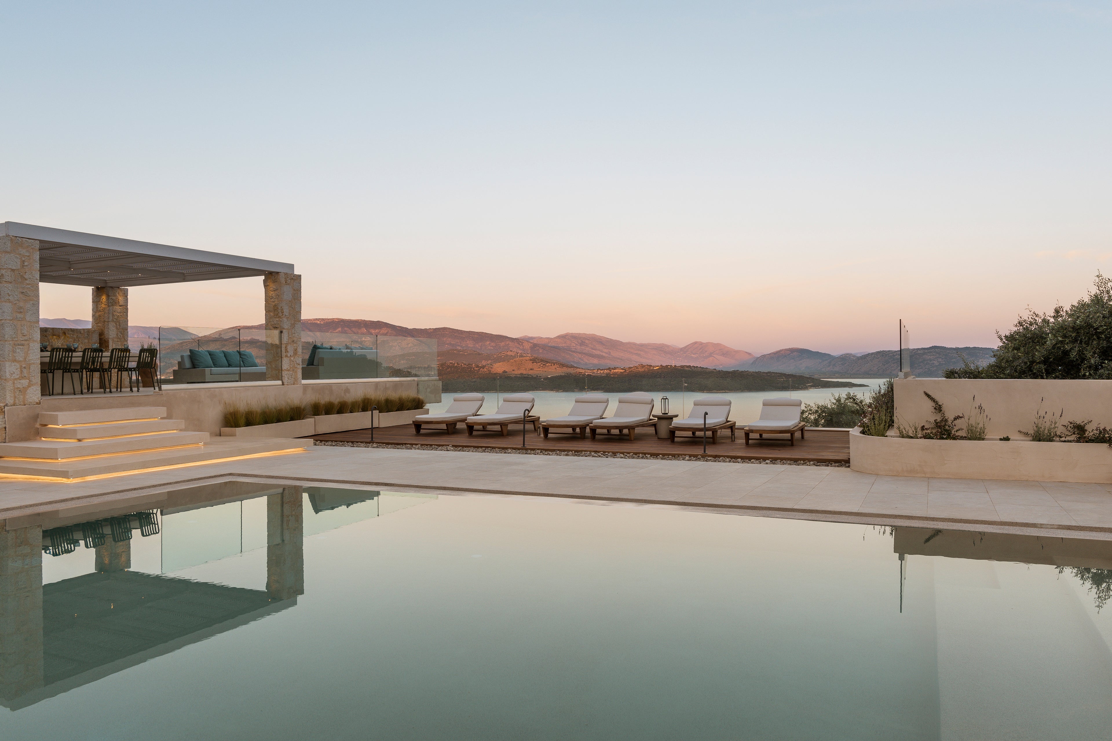 Luxury outdoor pool area with lounge chairs and scenic view