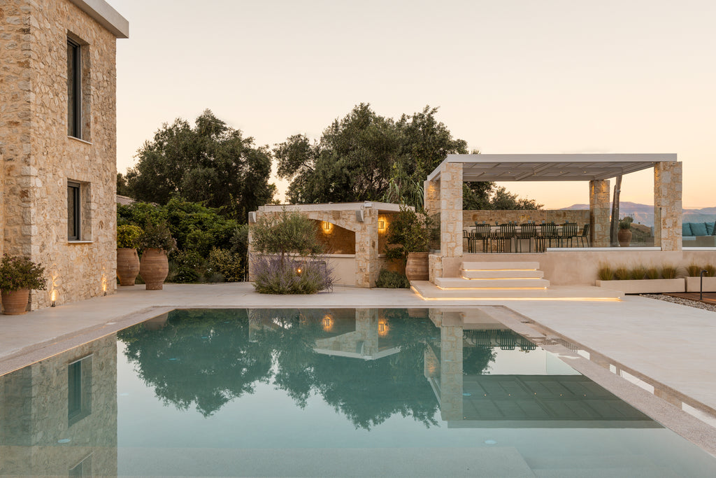 Pool area with stone building and outdoor furniture in a serene setting