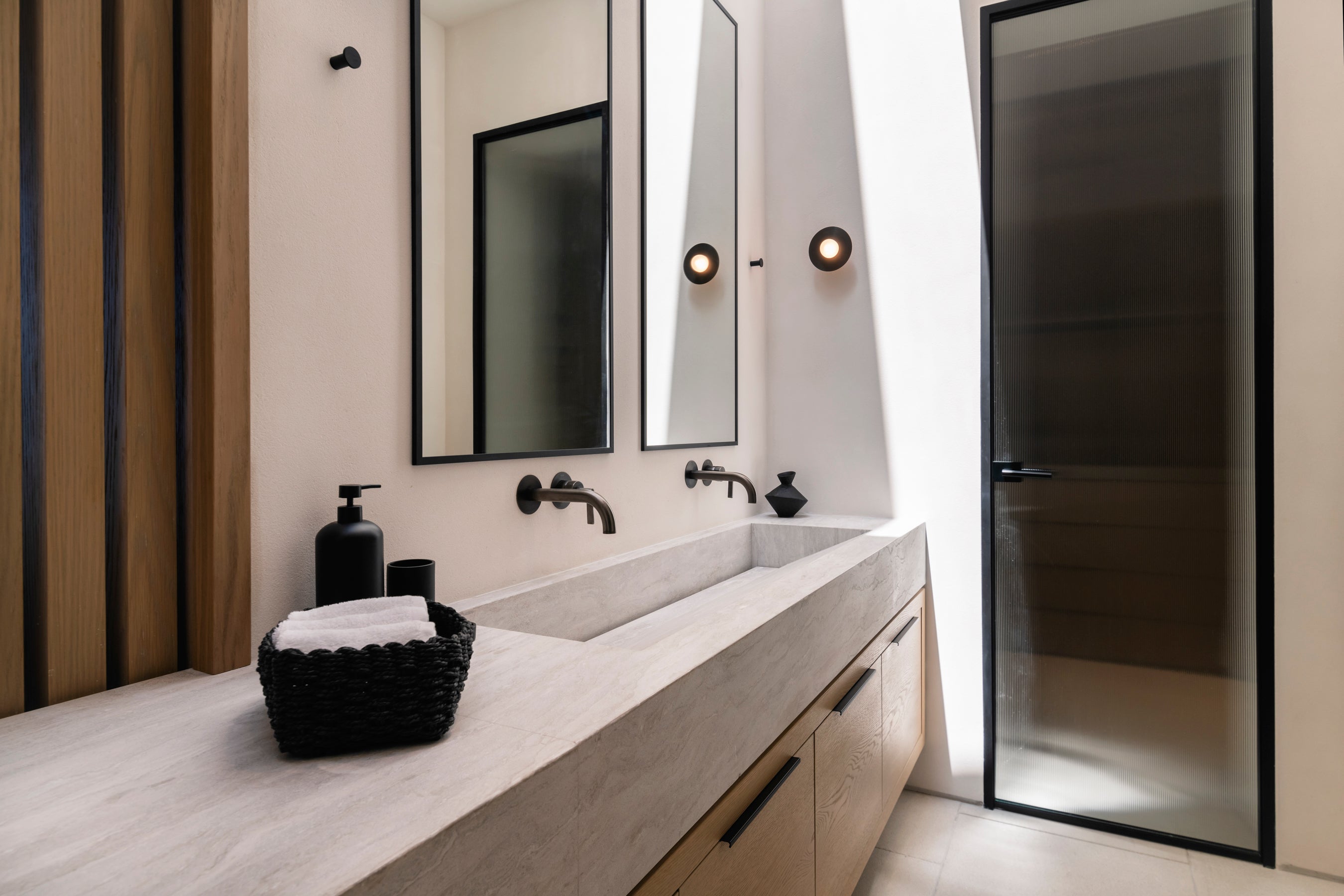 Modern bathroom with a vanity, mirror, and shower door.