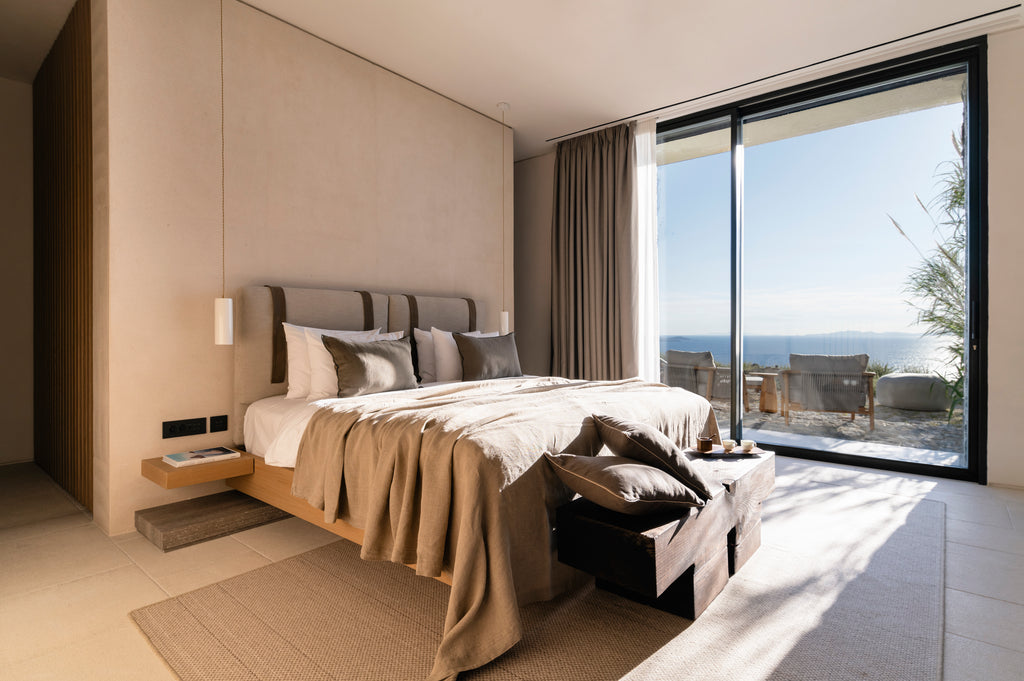 Modern bedroom with large windows overlooking a scenic view