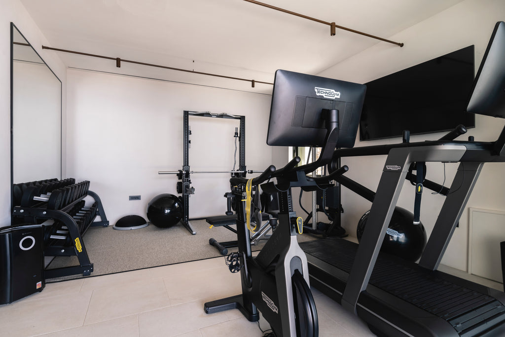 Gym interior with treadmill, weights, and exercise equipment.