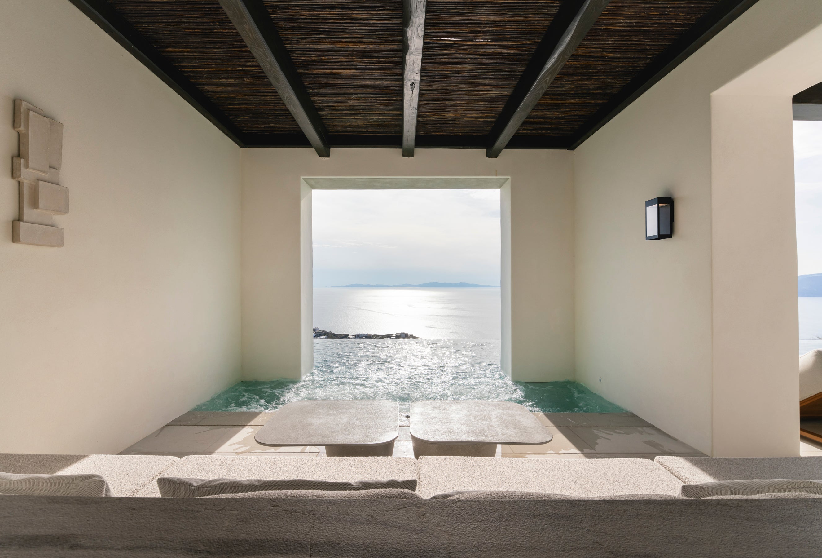 Modern indoor room with large window overlooking ocean