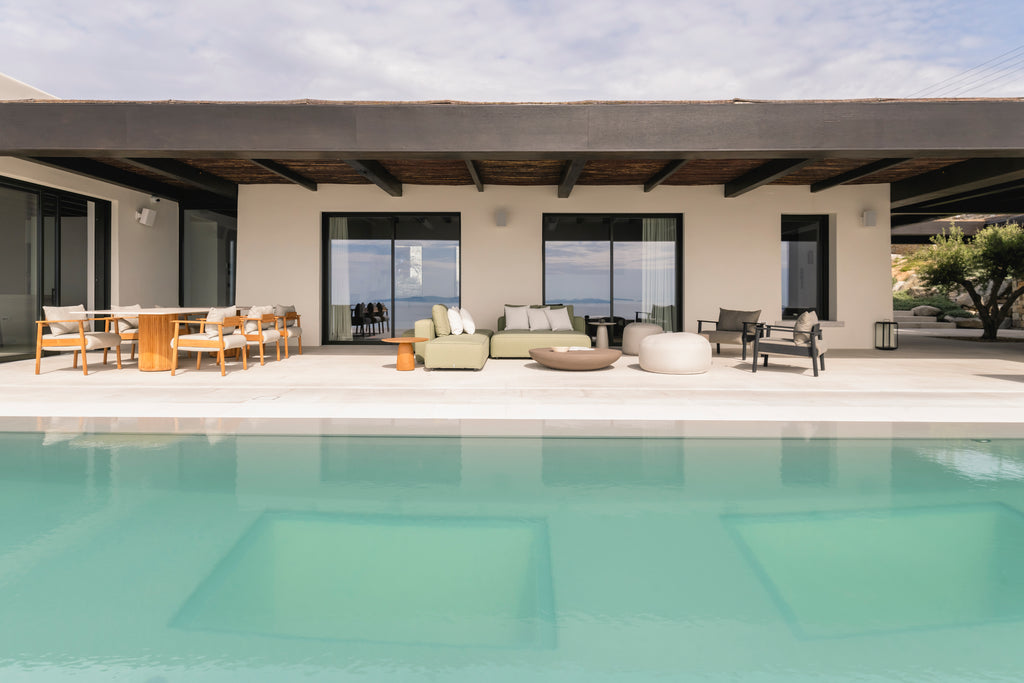 Modern outdoor patio area with furniture and pool in front of a house