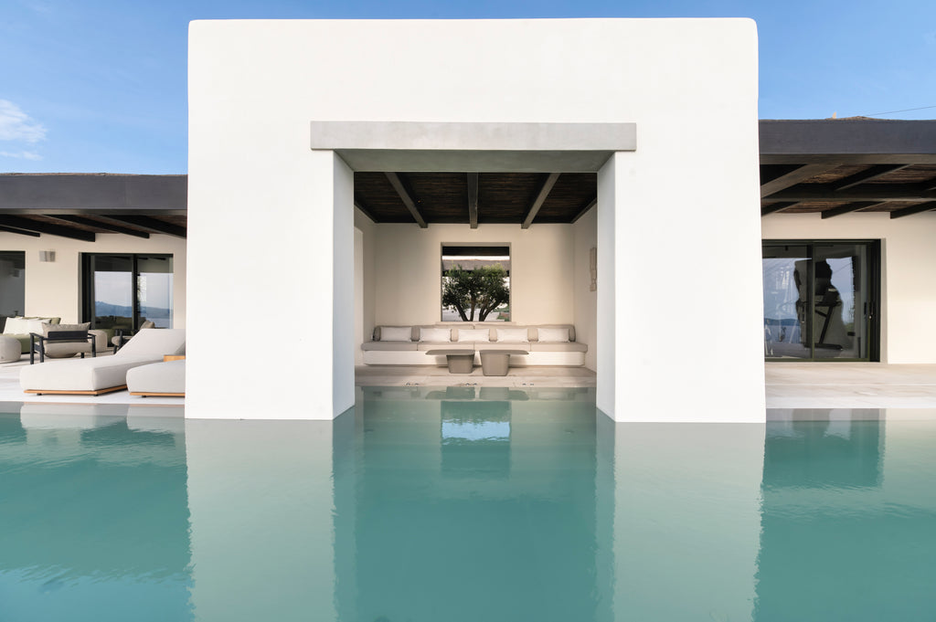 Modern house with a pool and outdoor seating area on a clear day